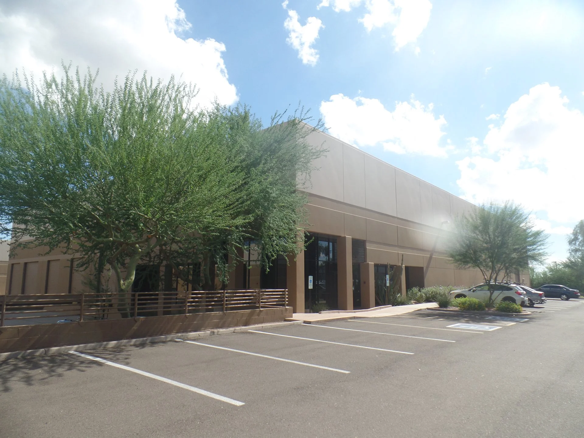 An industrial building with large windows, and tilt-panel walls.