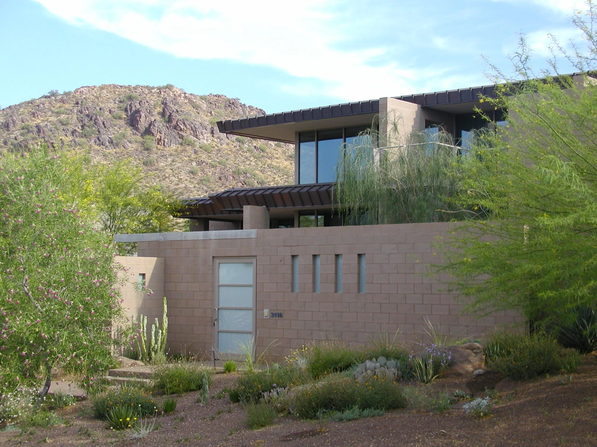 Modern house with desert landscaping and mountainous backdrop