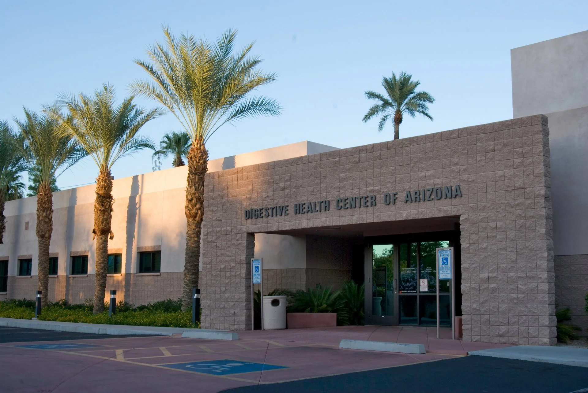 Exterior of Digestive Health Center of Arizona with palm trees and parking area
