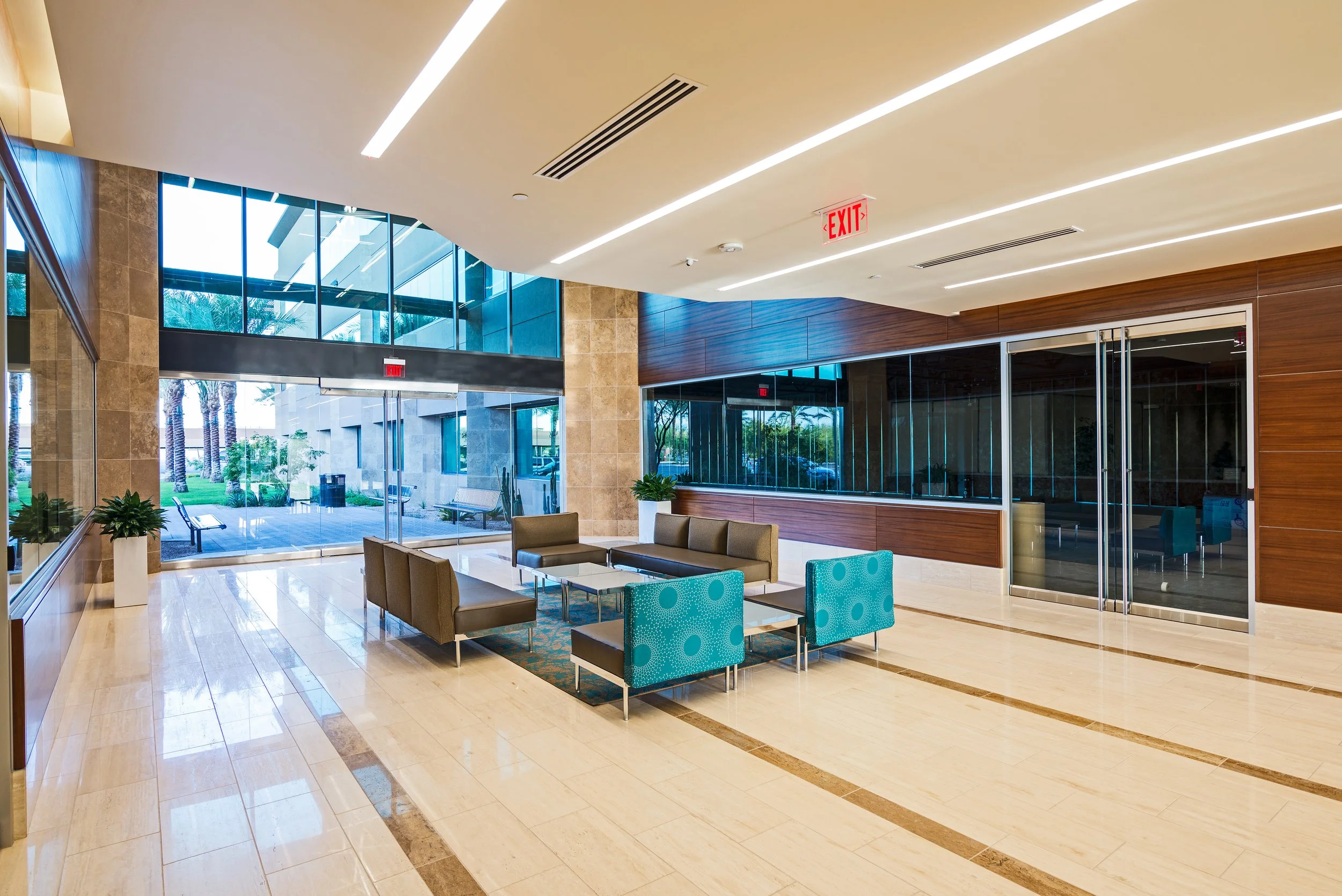 Modern office lobby with seating area, glass doors, and large windows at Chandler 202.