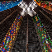Looking up at the interior of a tall building with colorful illuminated signage on its walls.