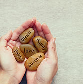 Hands holding six wooden blocks with inspirational words like 'Dream,' 'Love,' 'Success,' 'Vision,' 'Future,' and 'Faith'.