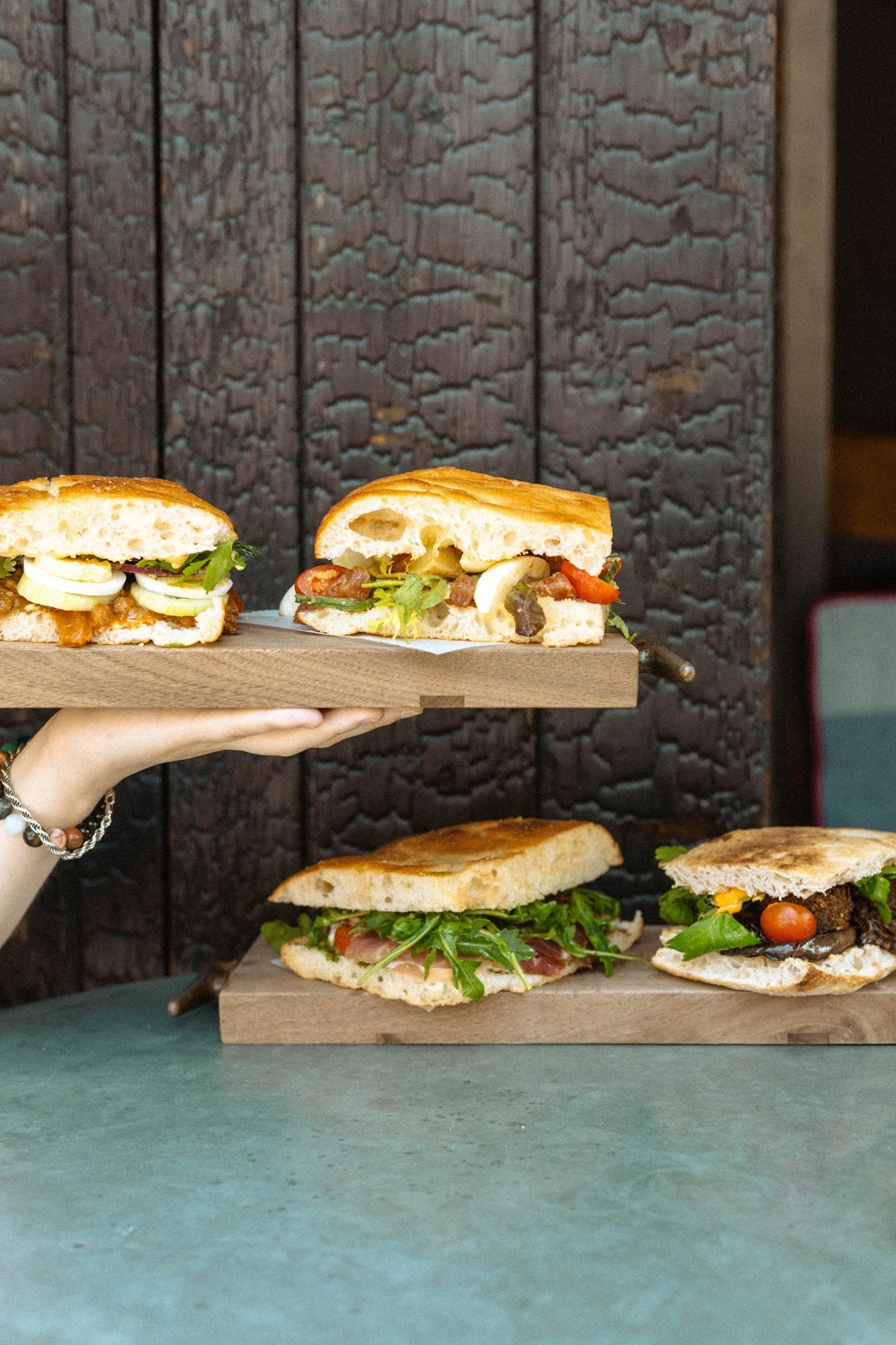 Photo of woman holding focaccia sandwiches at zinqué, a French restaurant