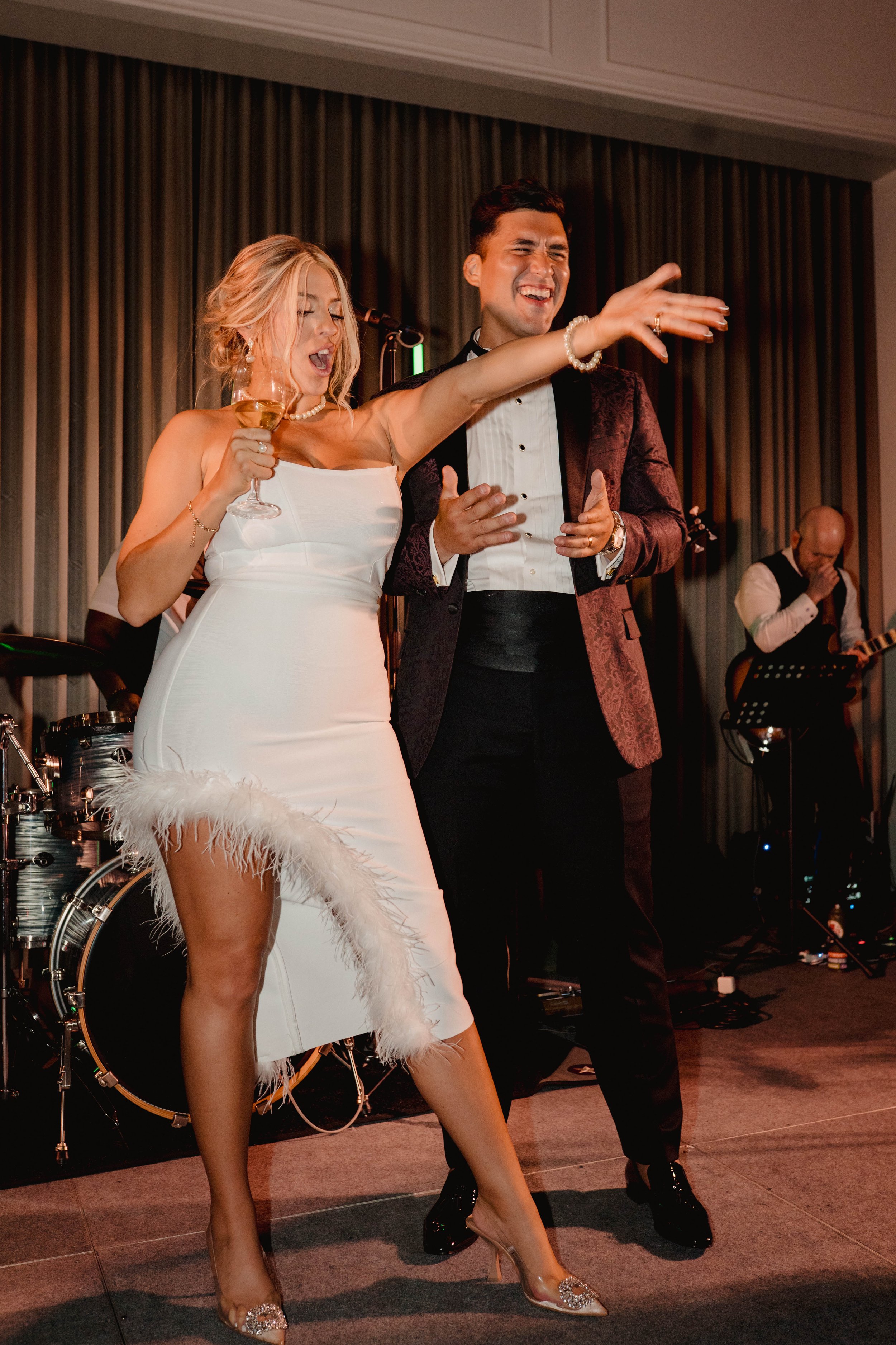 a couple is dancing and singing on the stage of their reception