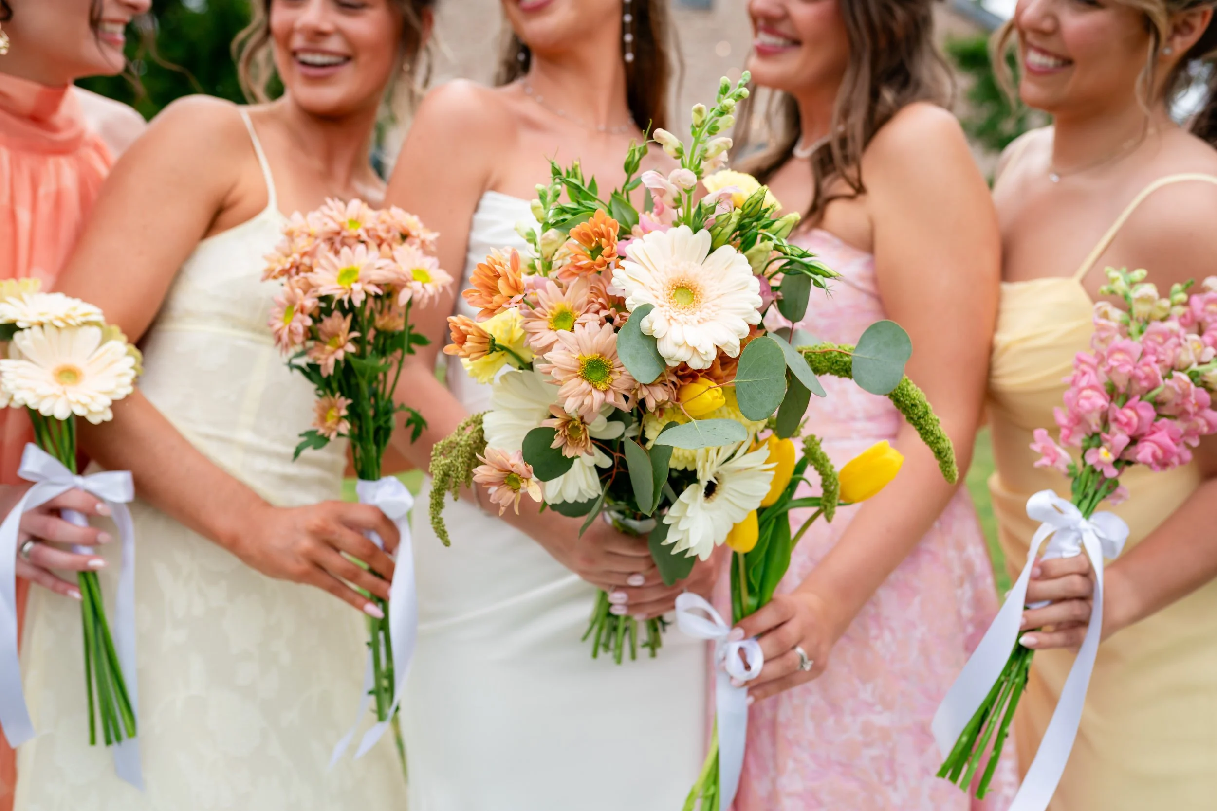 a bride is with her bridesmaids holding their bouquets