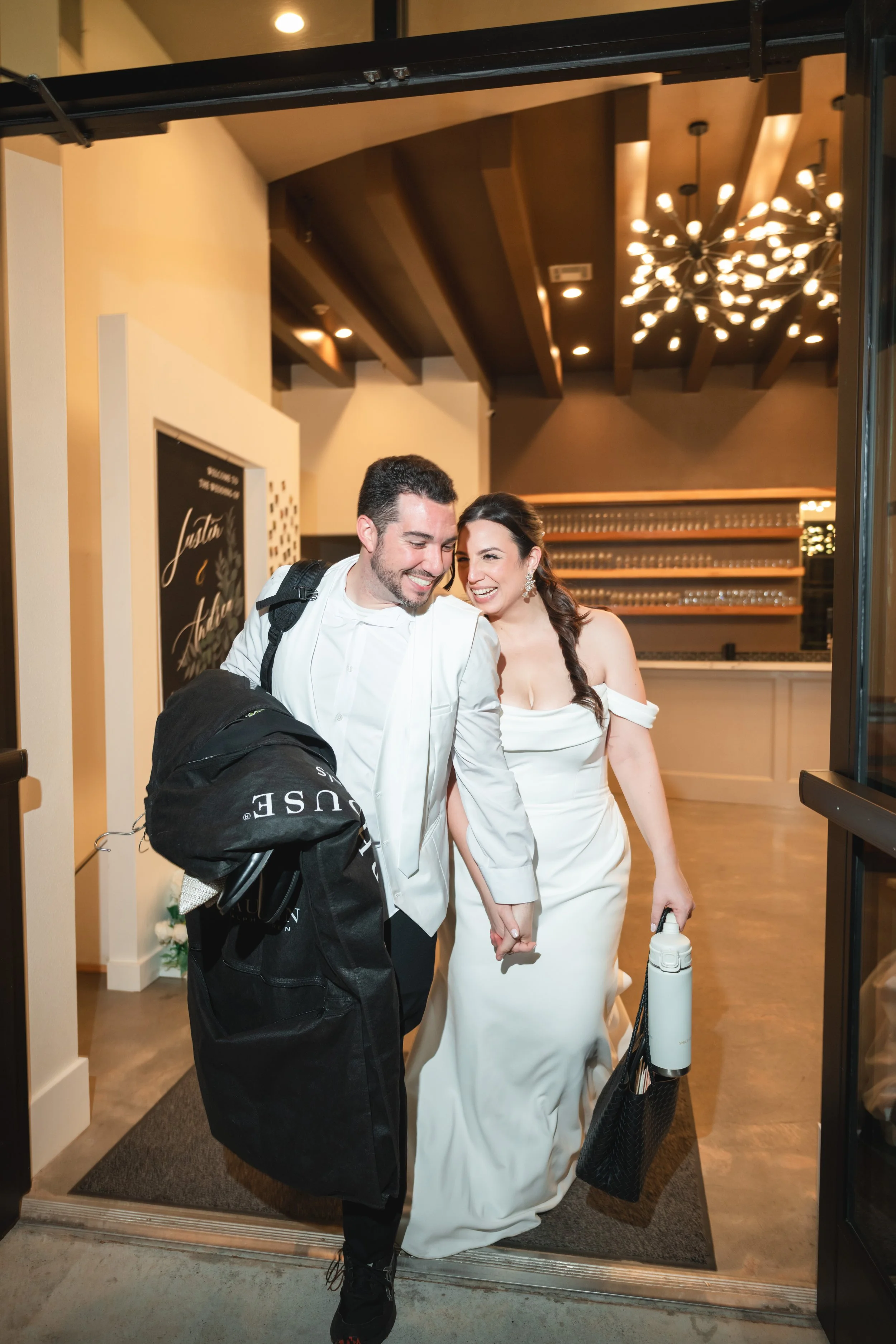 bride and groom are leaving the reception with their belongings