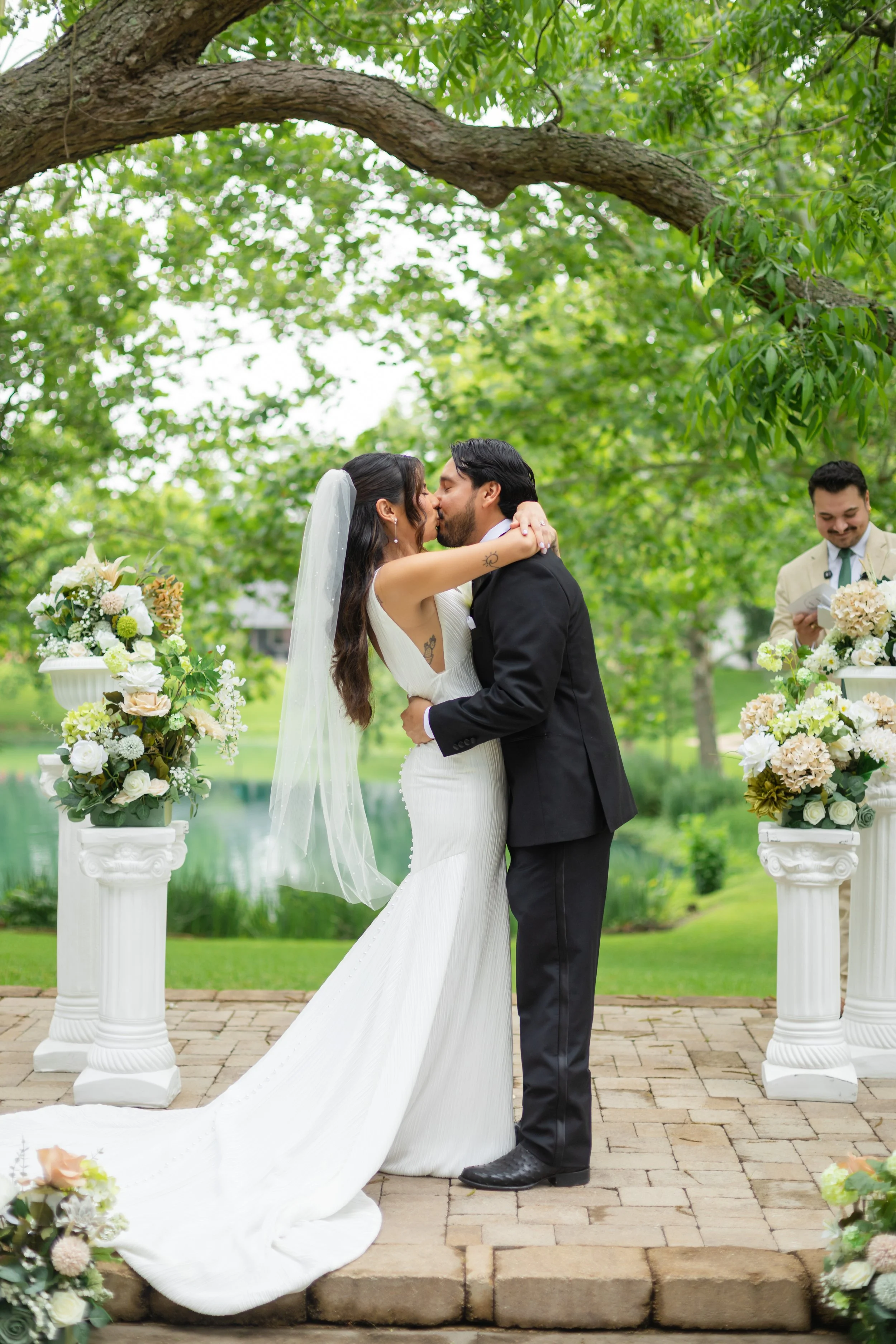 a bride and groom kissing at the alter outside 