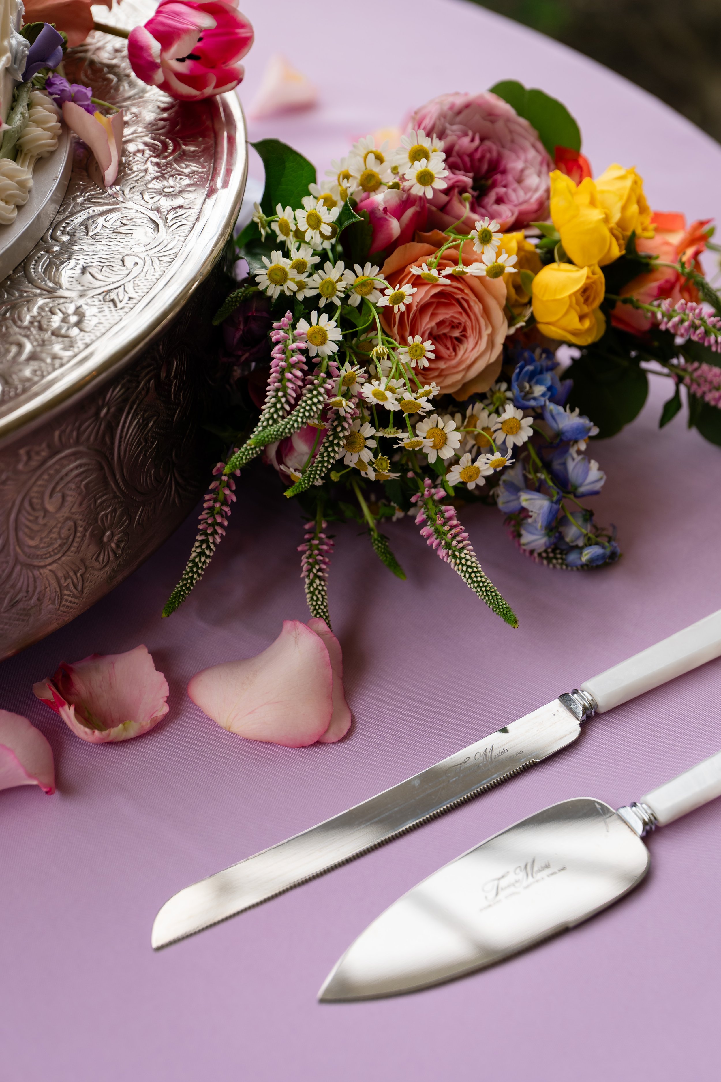 a close up picture of a cake knife and flowers