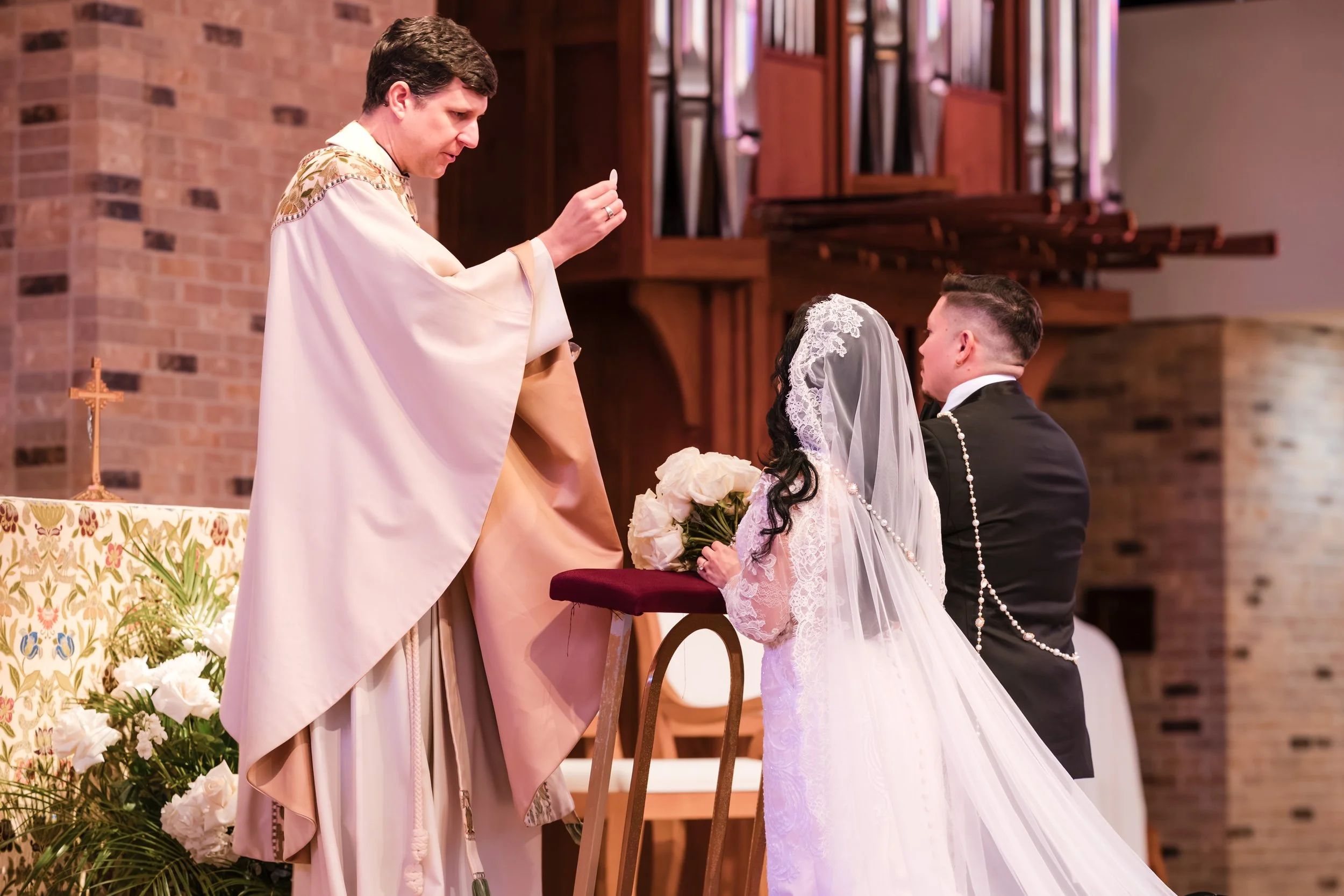 a priest is giving a bride and groom their blessing at the church