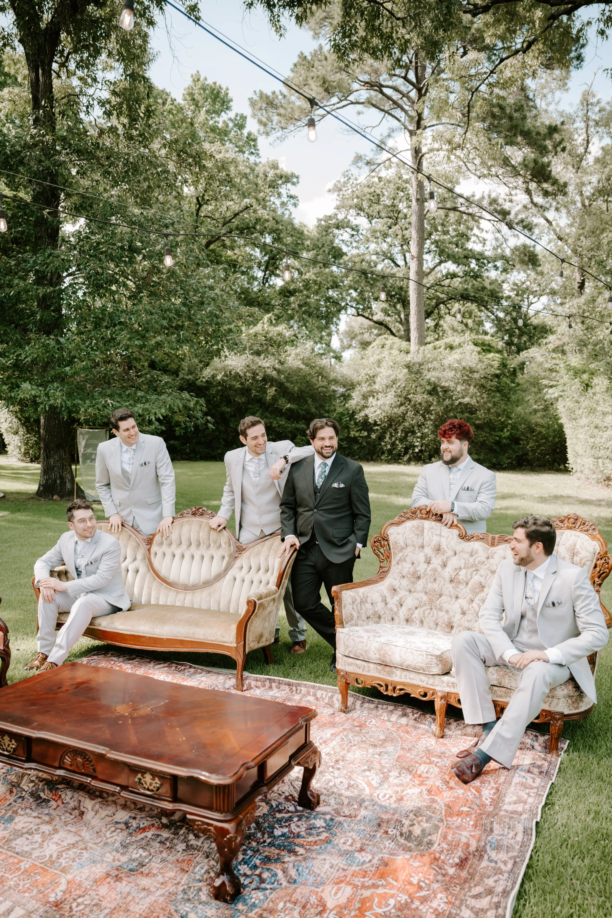 a groom and his groomsmen are posing in front of furniture on a field