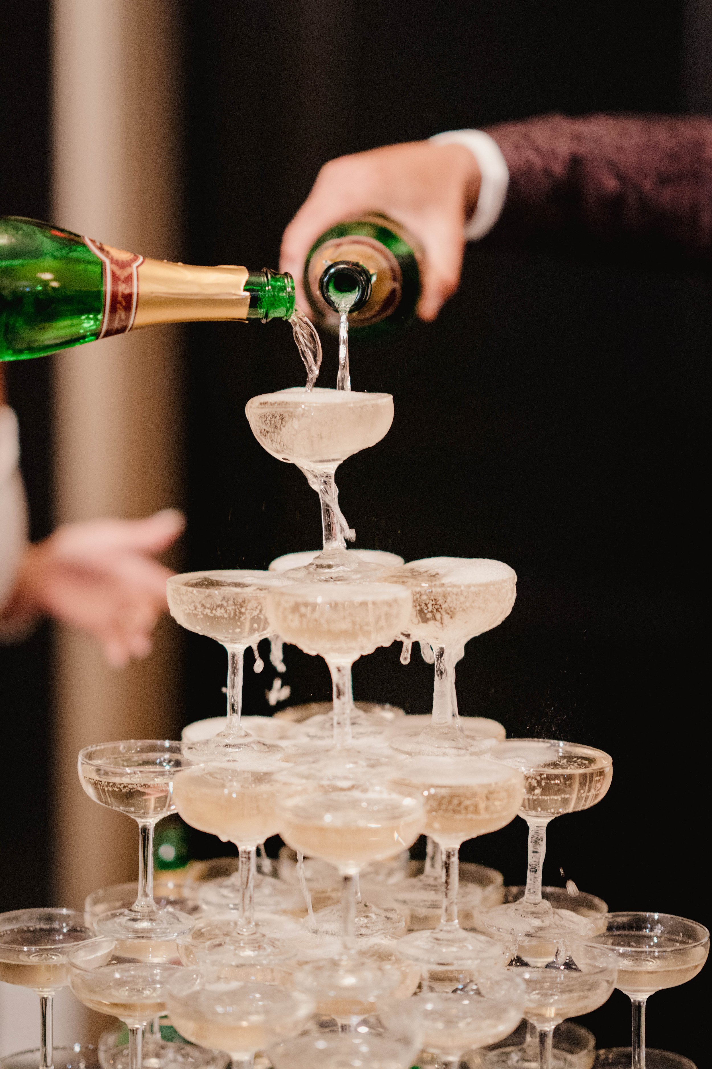 a person is pouring champagne into couple glasses 