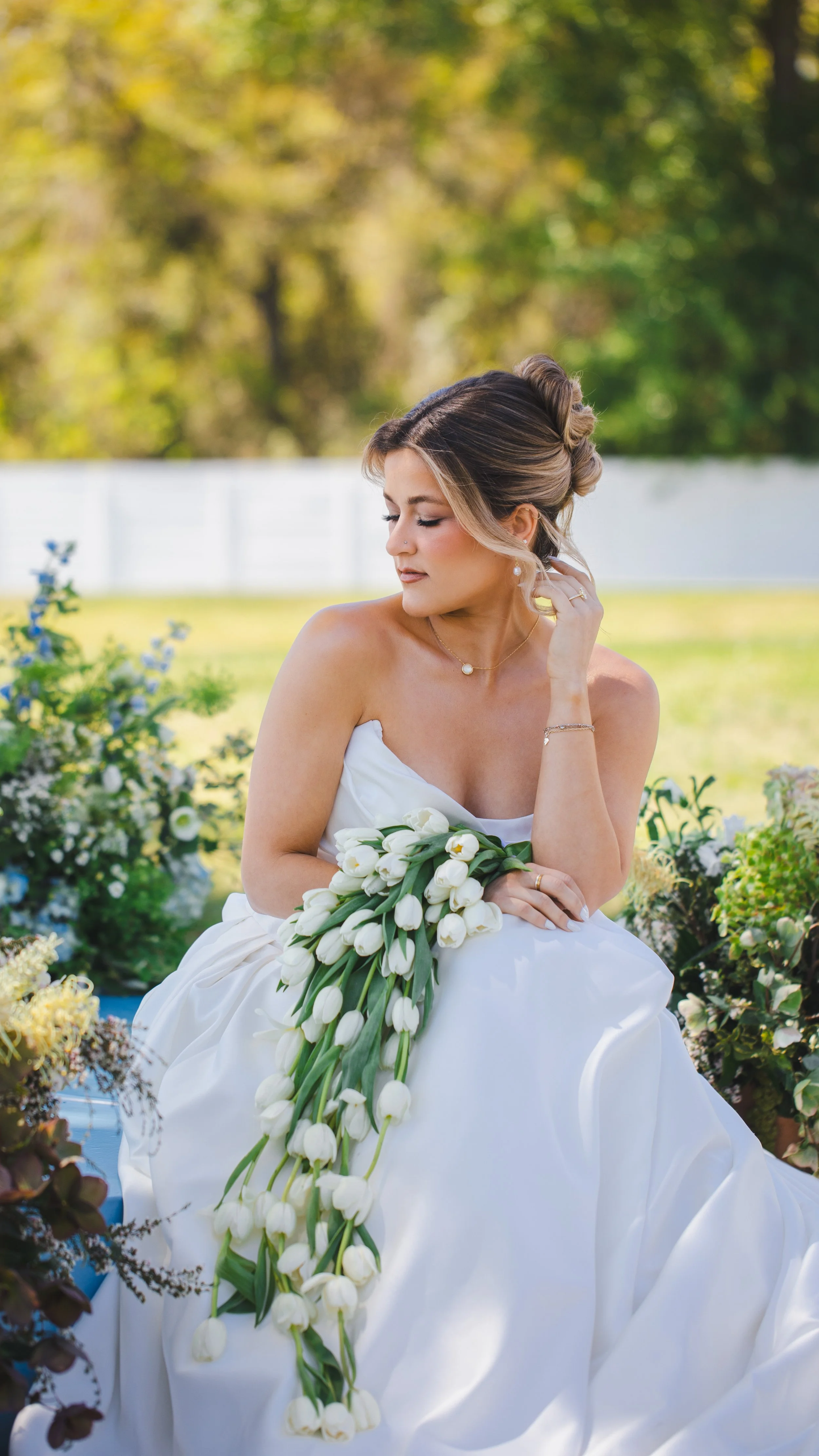 a bride is holding her flowers and looking off into the distance 
