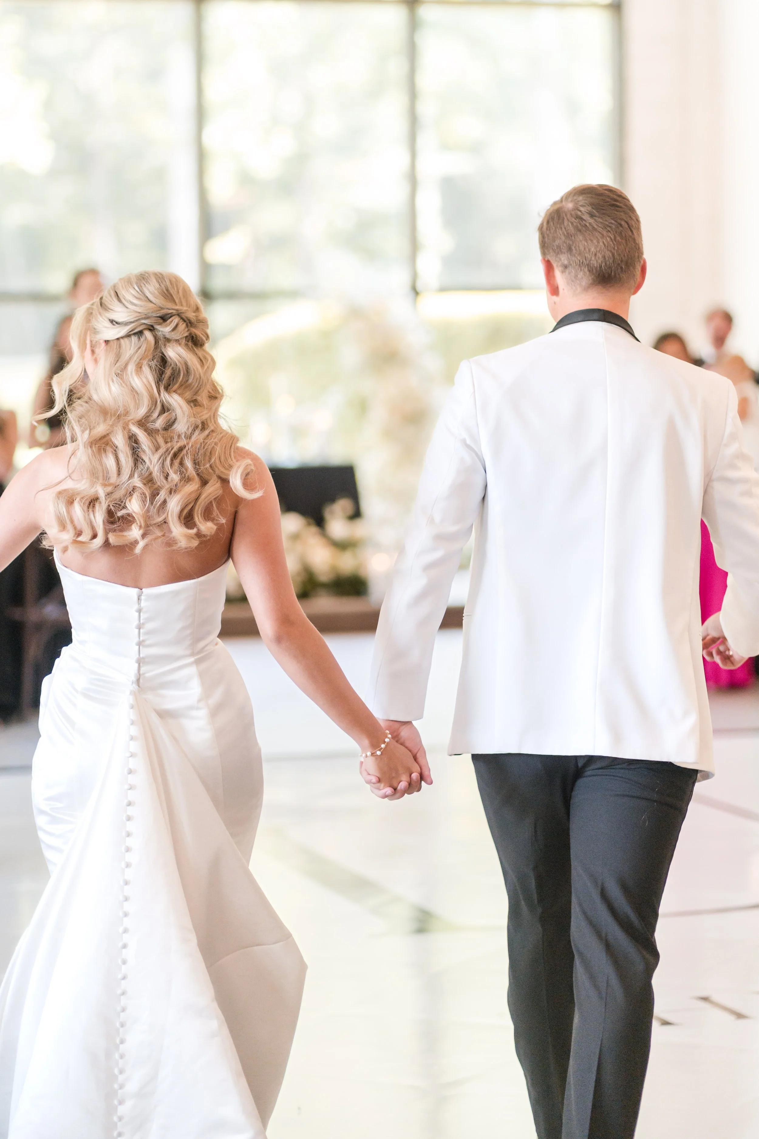bride and groom entering towards their first dance on the dancefloor