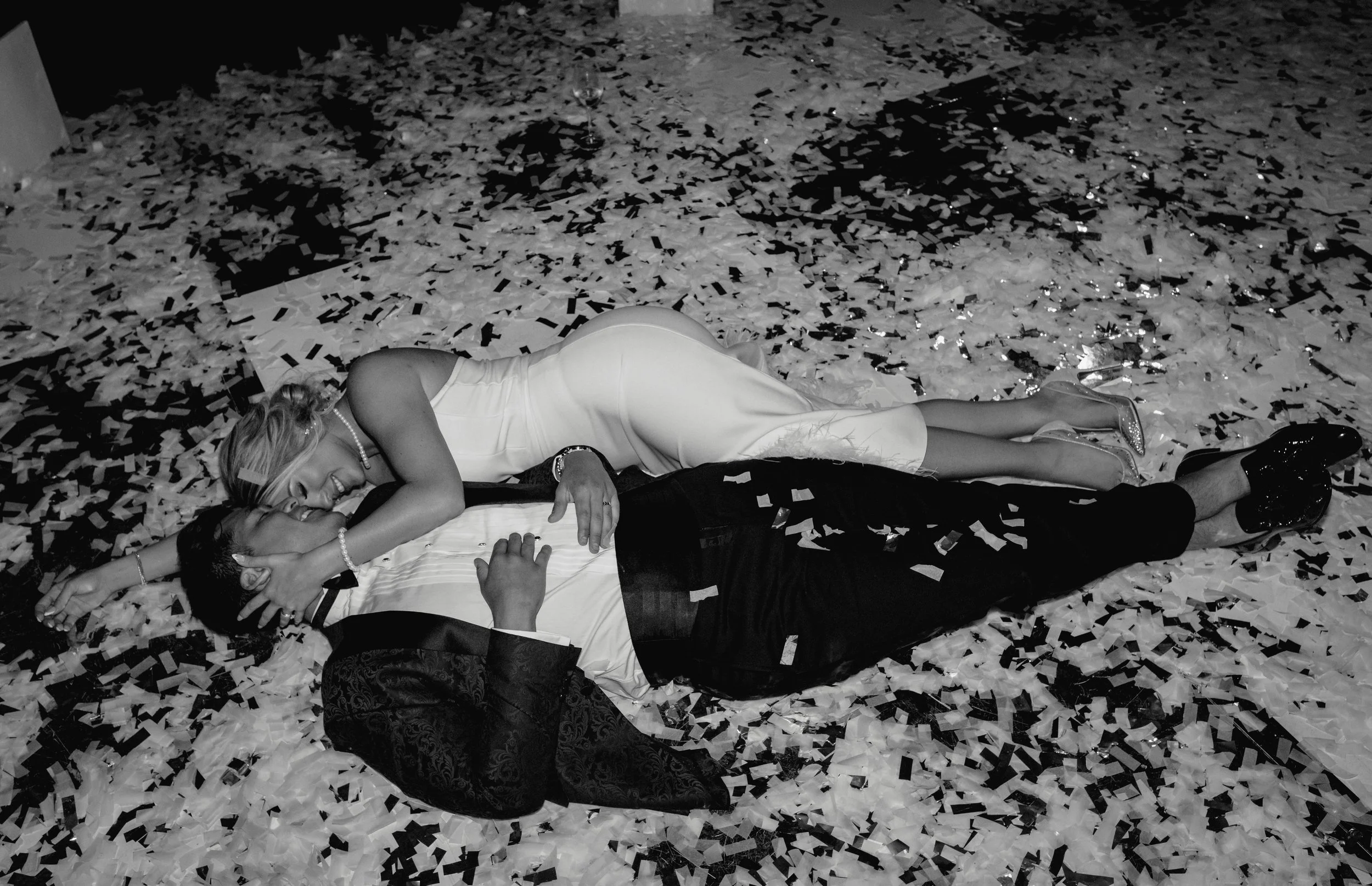 a couple is in confetti on the dance floor