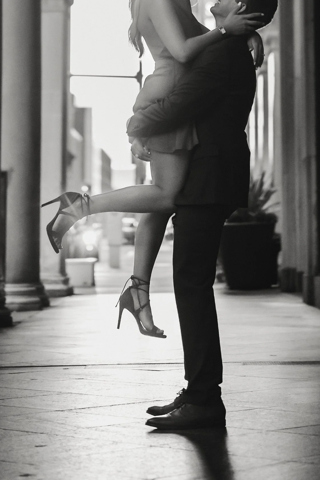 a couple is taking engagement pictures and groom is picking her up