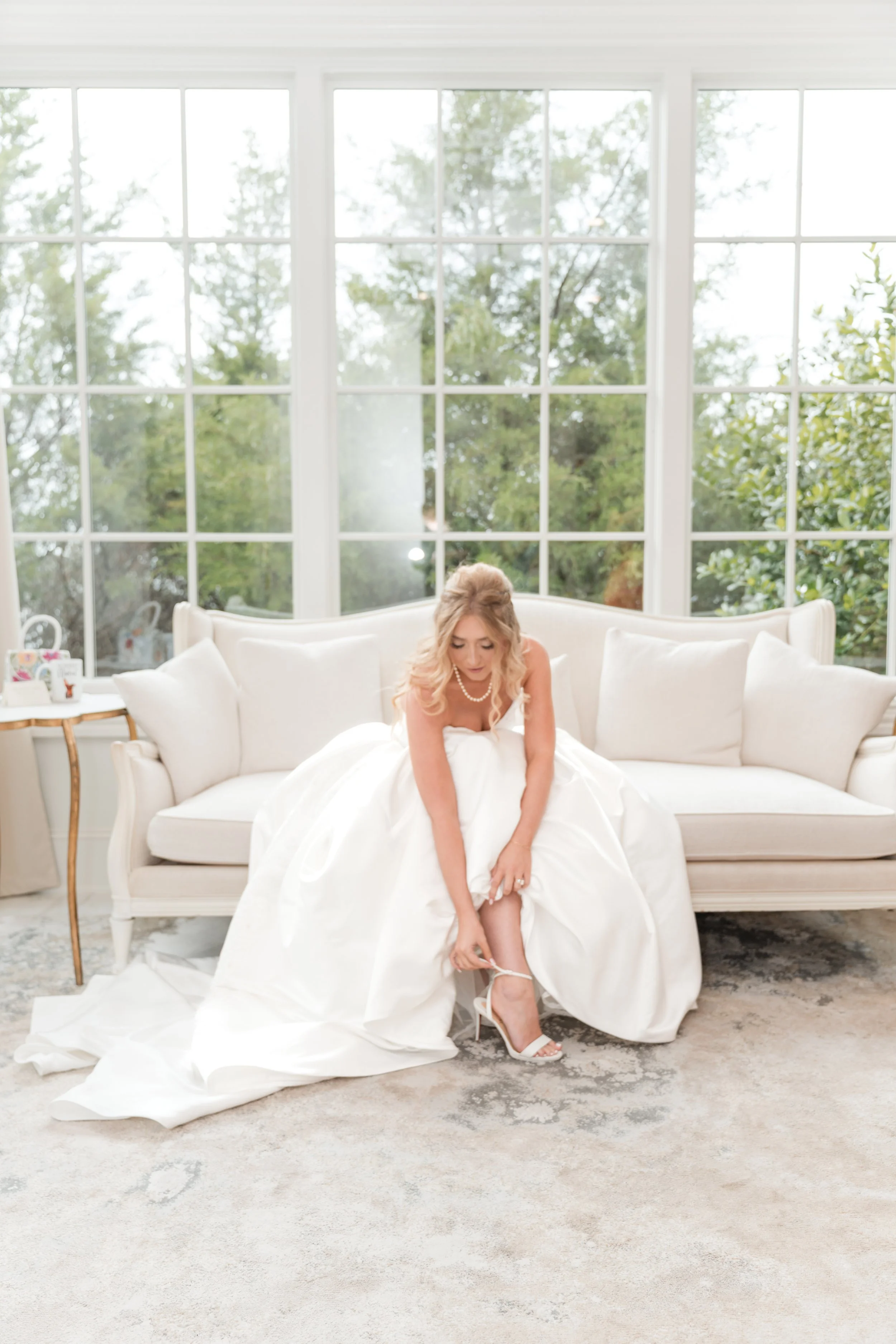 a bride is fixing her shoe while in her wedding dress