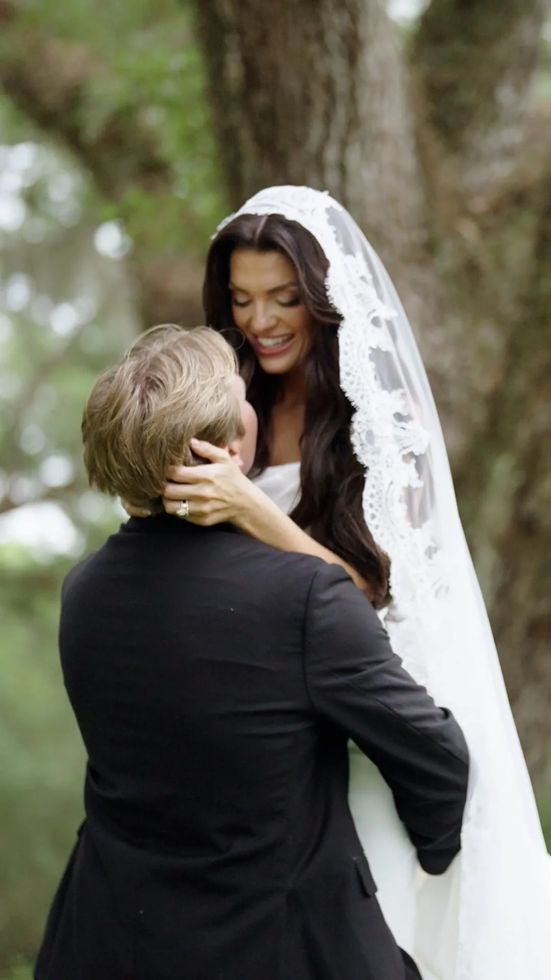 a bride being carried by her husband and wearing a cathedral veil