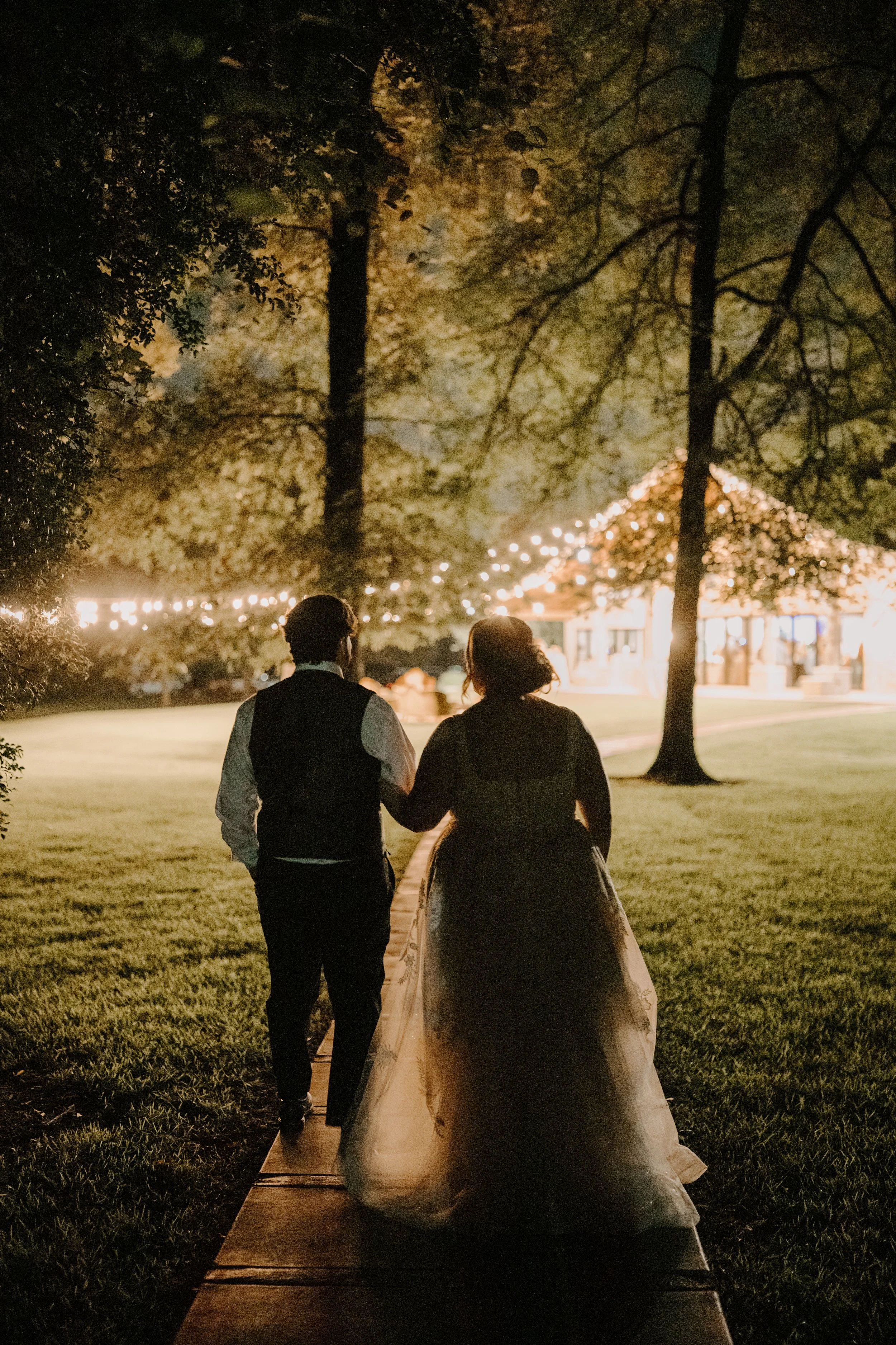 a couple is entering their reception in the dark 