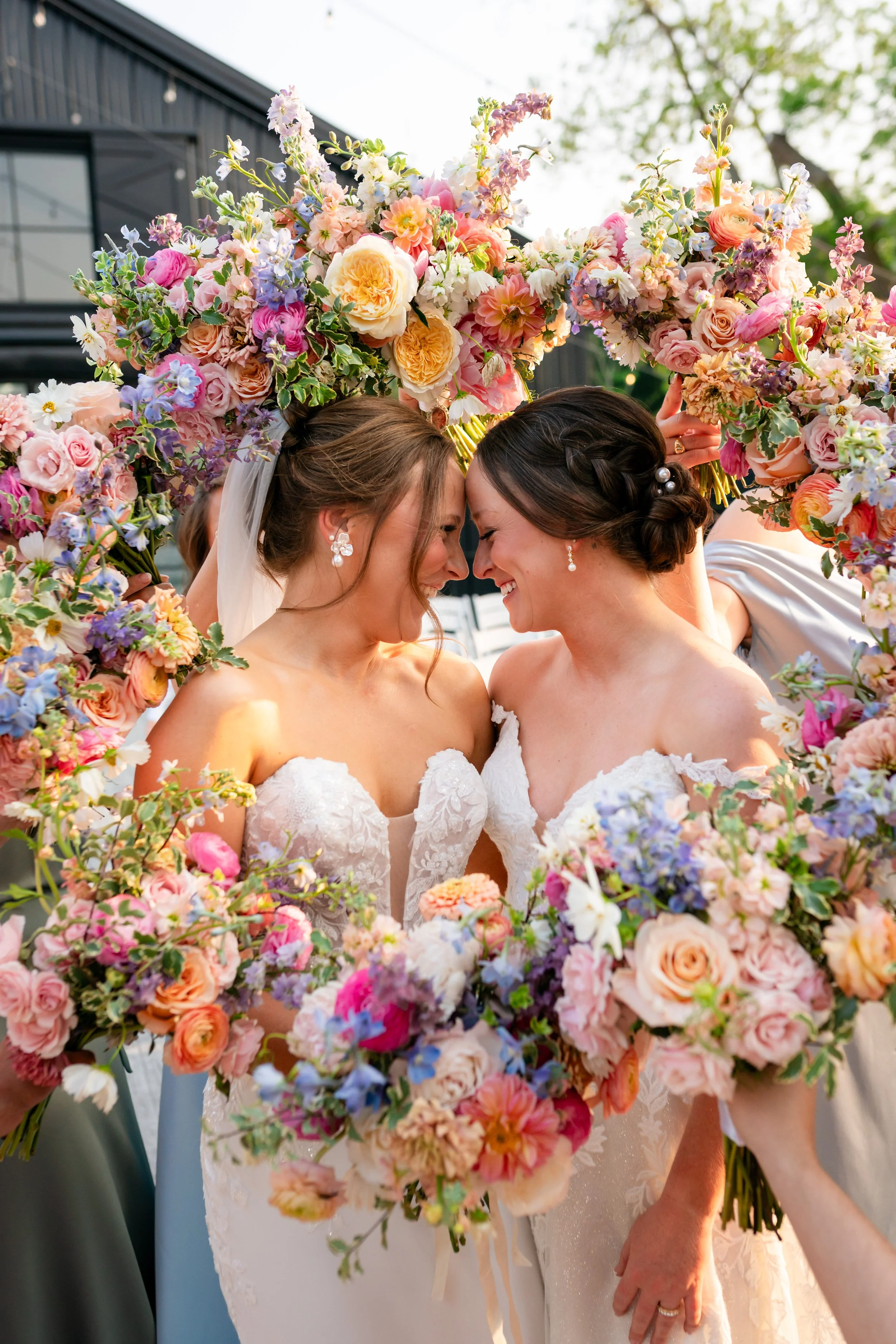 two brides looking at each other with flowers surrounding their faces