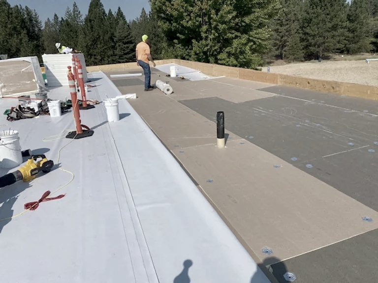 Rooftop construction site with worker and materials