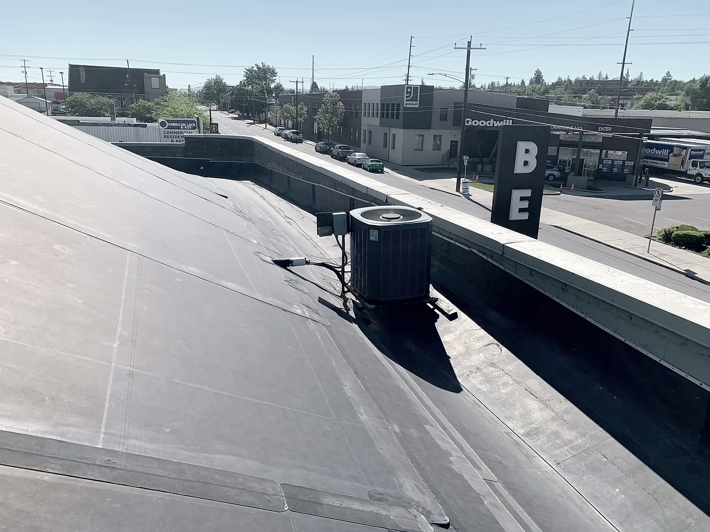 Rooftop view with HVAC unit, and Goodwill store visible across the street.