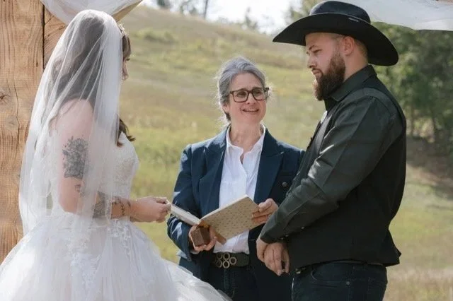 Nadia Pruett Wedding Officiant performing a wedding ceremony with a bride and groom wearing a black cowboy hat.