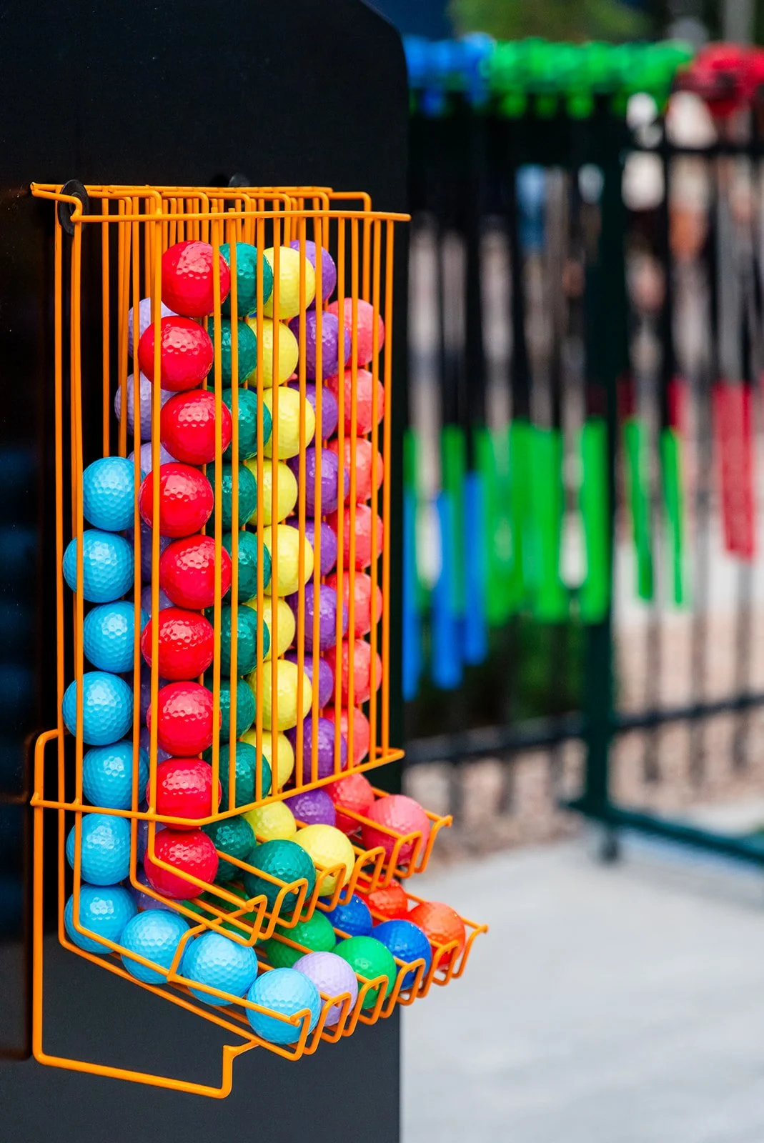 Mini golf course with two putters and colorful balls near a hole on green turf.