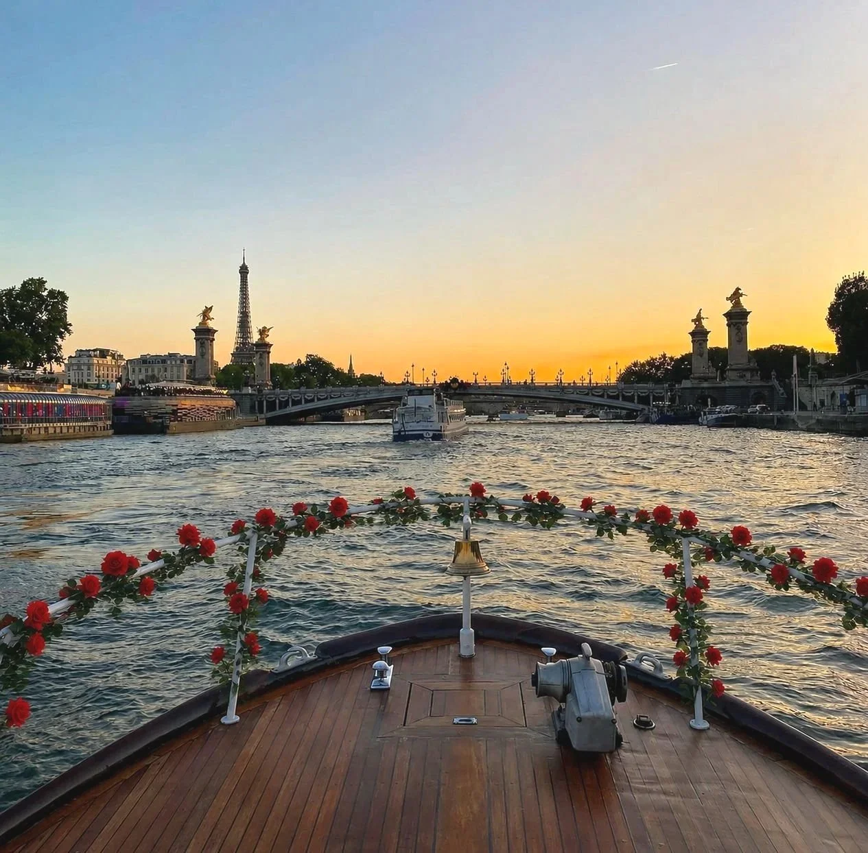 Proue d'un bateau décorée de fleurs rouges et feuillage.