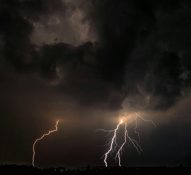 Dark stormy sky with multiple lightning strikes.
