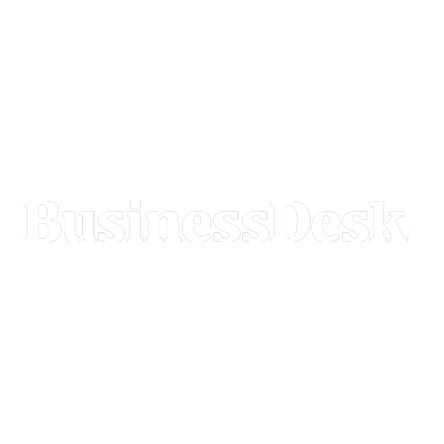 Sign with the words "Business Desk" in gray text on a white background.