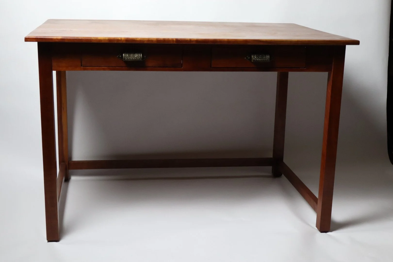 This Cherry Desk has been used every day for the past 15 years. All are handcrafted using traditional joinery methods. Desks like this can be made to any dimension that would fit your space. This desk has two drawers; it can be built with one or none