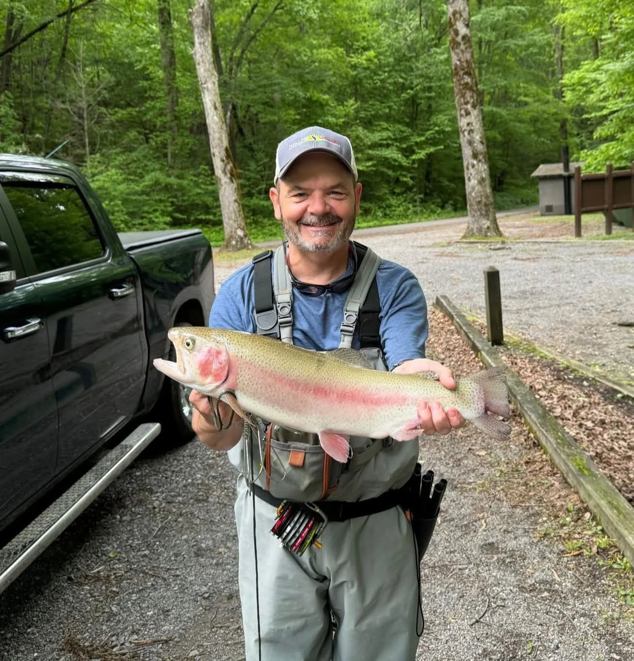 Andy Blue holding a trout smiling.