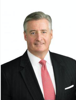 A professional man in a black suit, white shirt, and red tie, smiling at the camera.