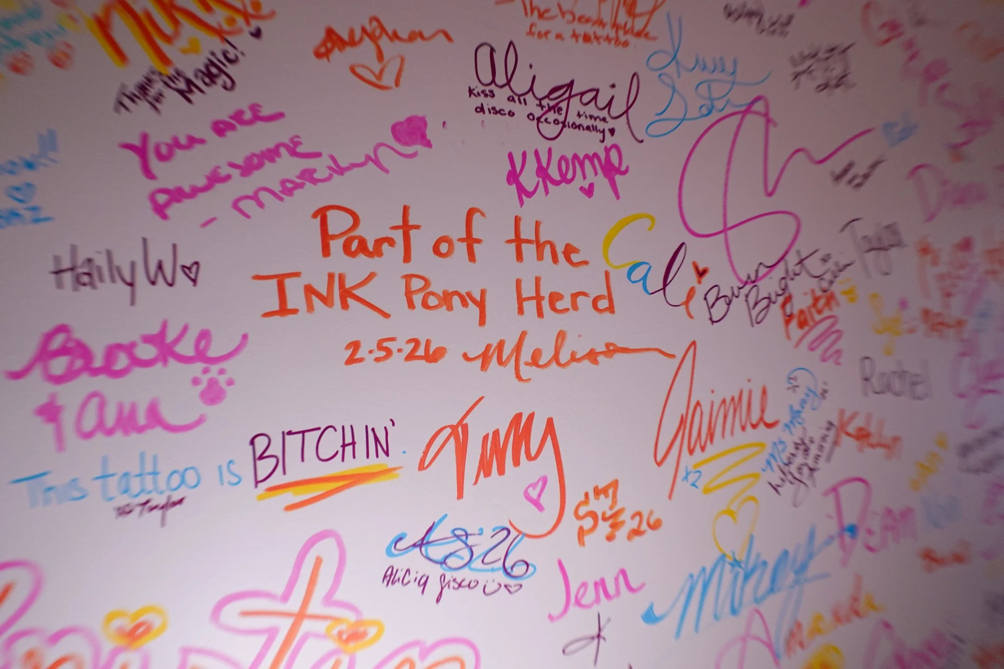 Colorful signatures on the Ink Pony Club’s signature wall of fame in Boise a tattoo shop in Boise Idaho.