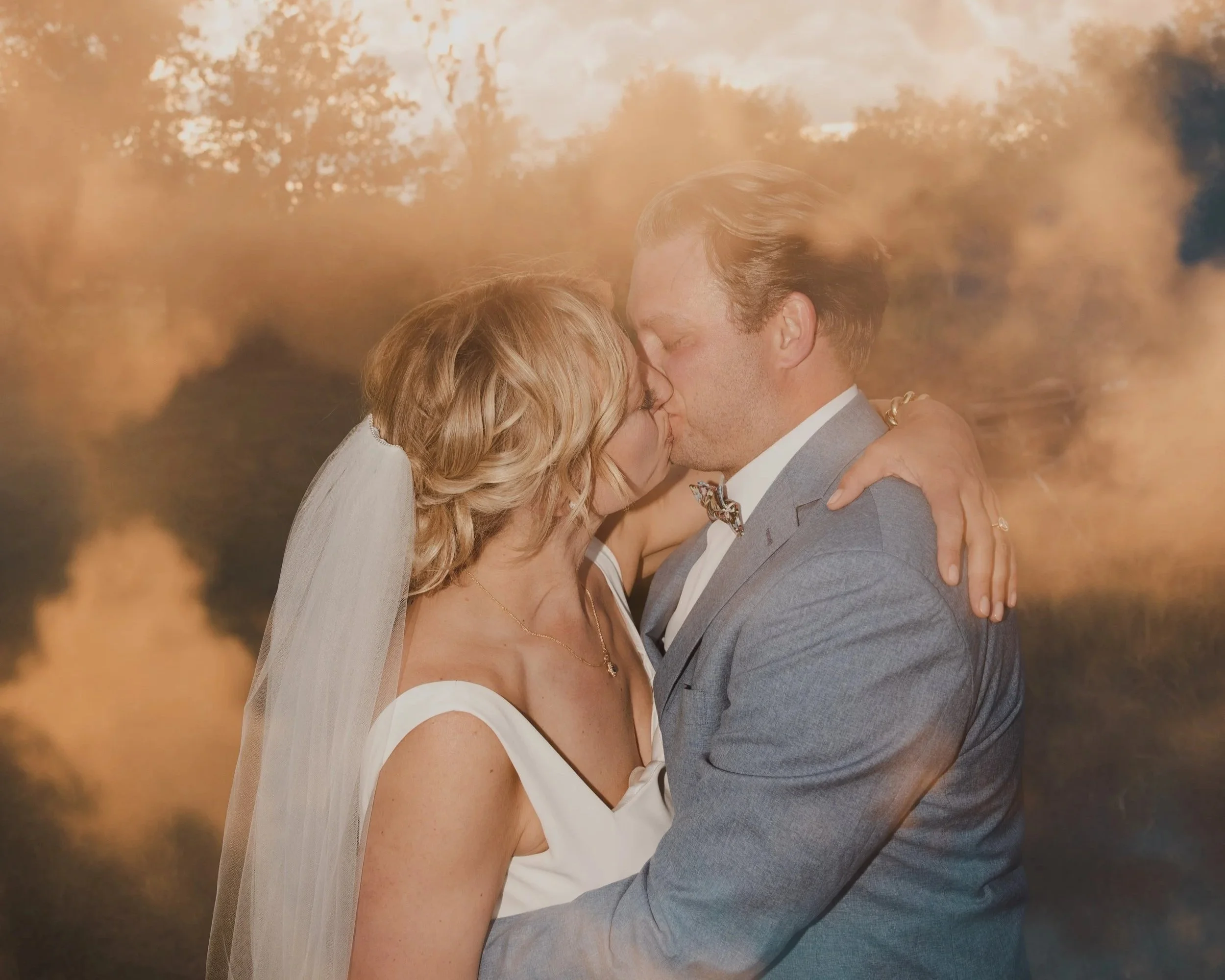 Couple celebrating, dressed in formal attire; man drinking from champagne bottle outdoors. photographed by a Los Angeles wedding photographer