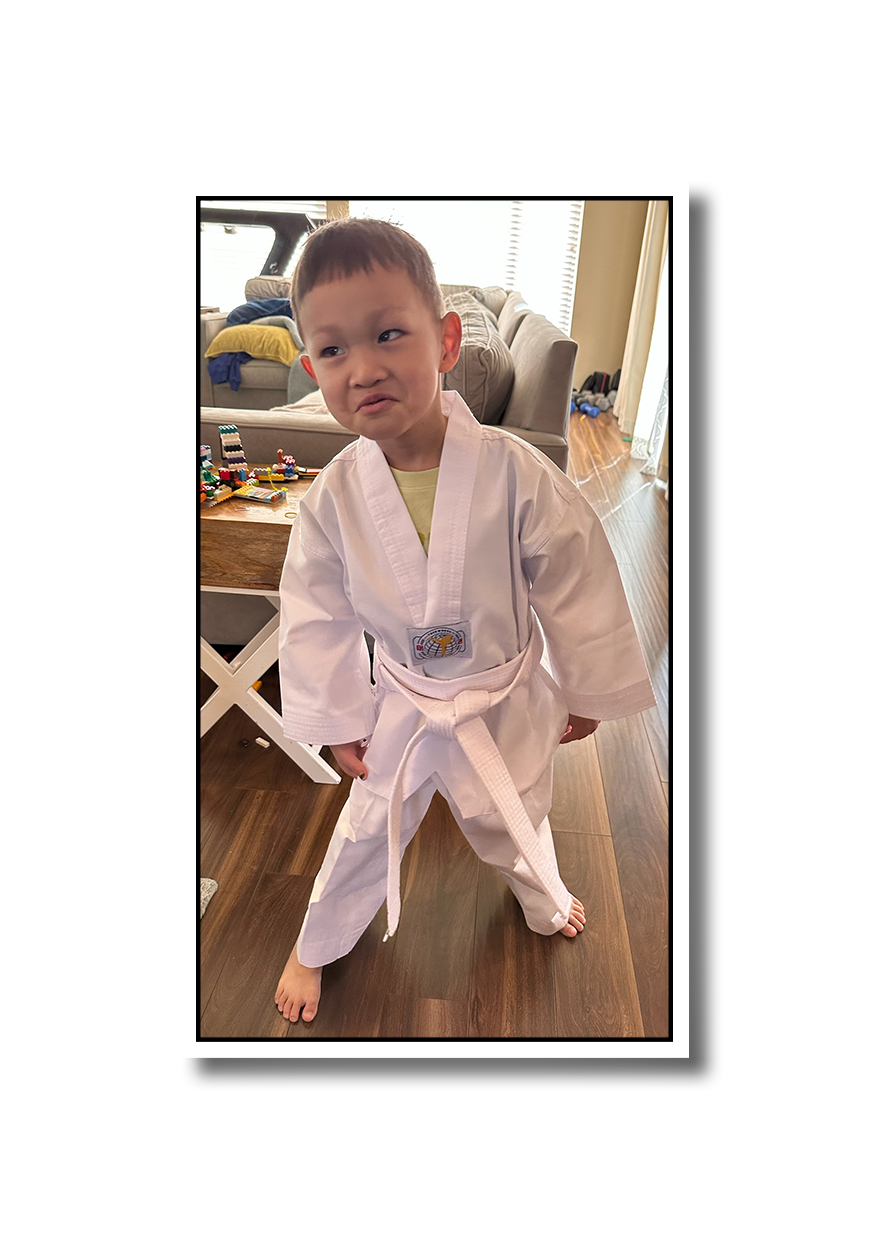 Noah poses in his Karate uniform with a goofy face.