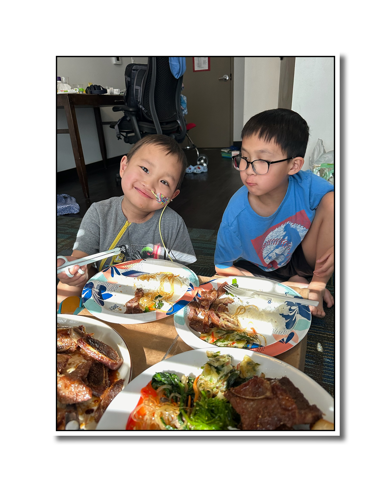 Noah and Kyle enjoying a spread of Korean takeout from their family hotel room.