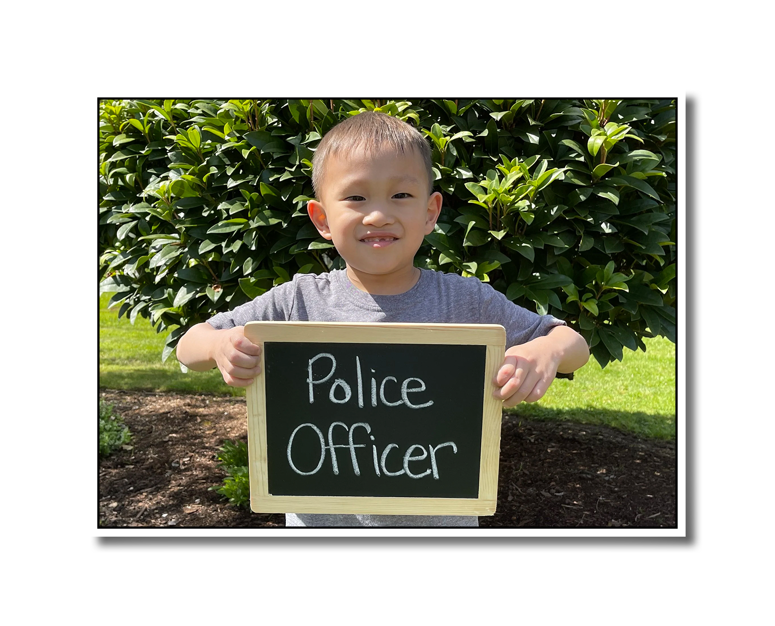 Noah holding a chalkboard sign that says Police Officer