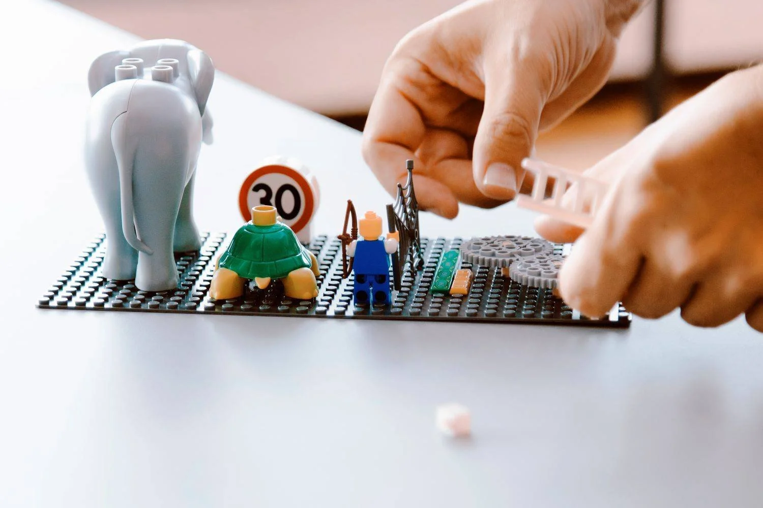 Kollerboration_Simon_Koller_Organisationsentwicklung_Lego_Serious_Play_zwei Händen bauen ein buntes Gebilde