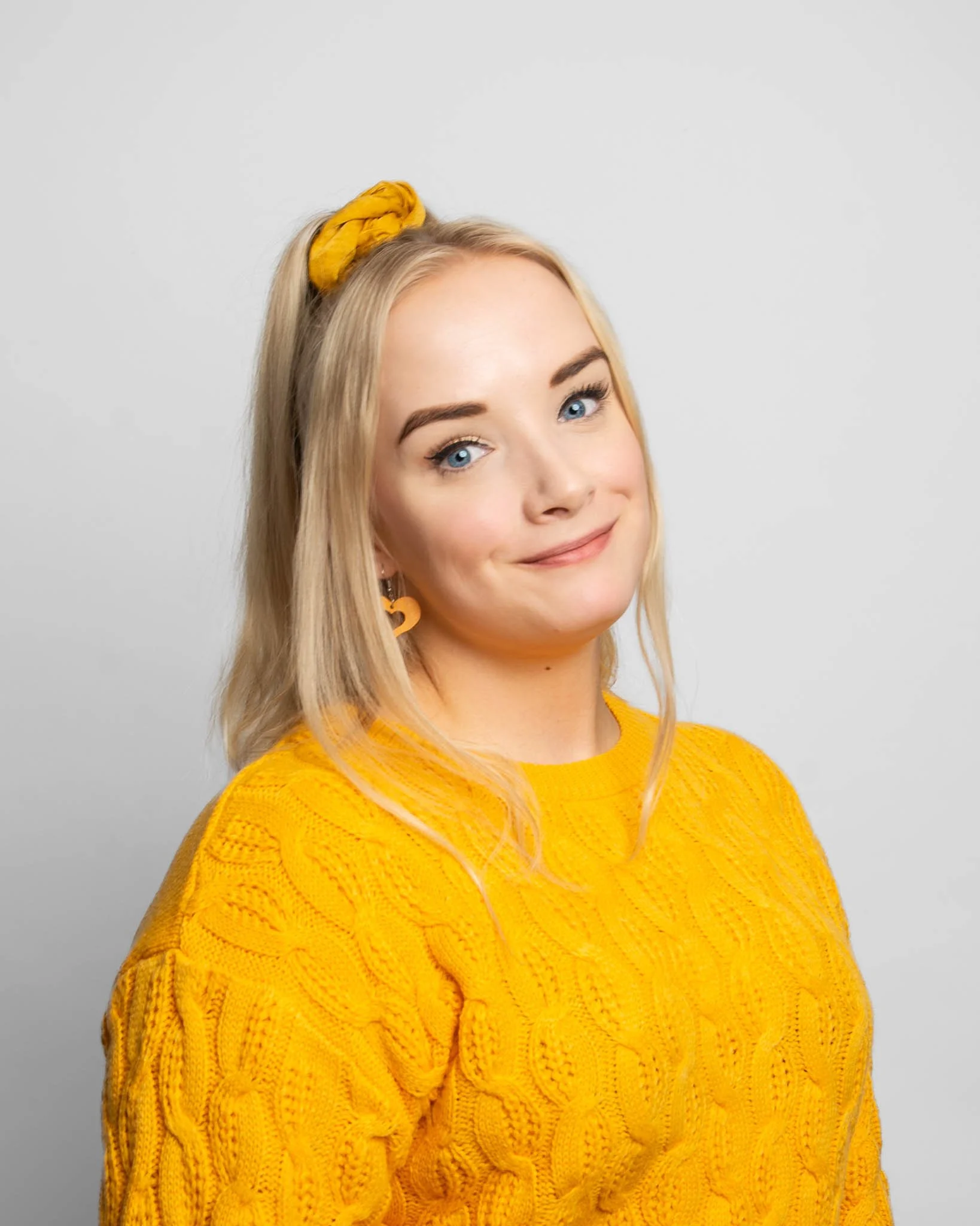 Henkilökuntaan kuuluva lyhytterapeutti henkilökuvassa keltainen neule päällä