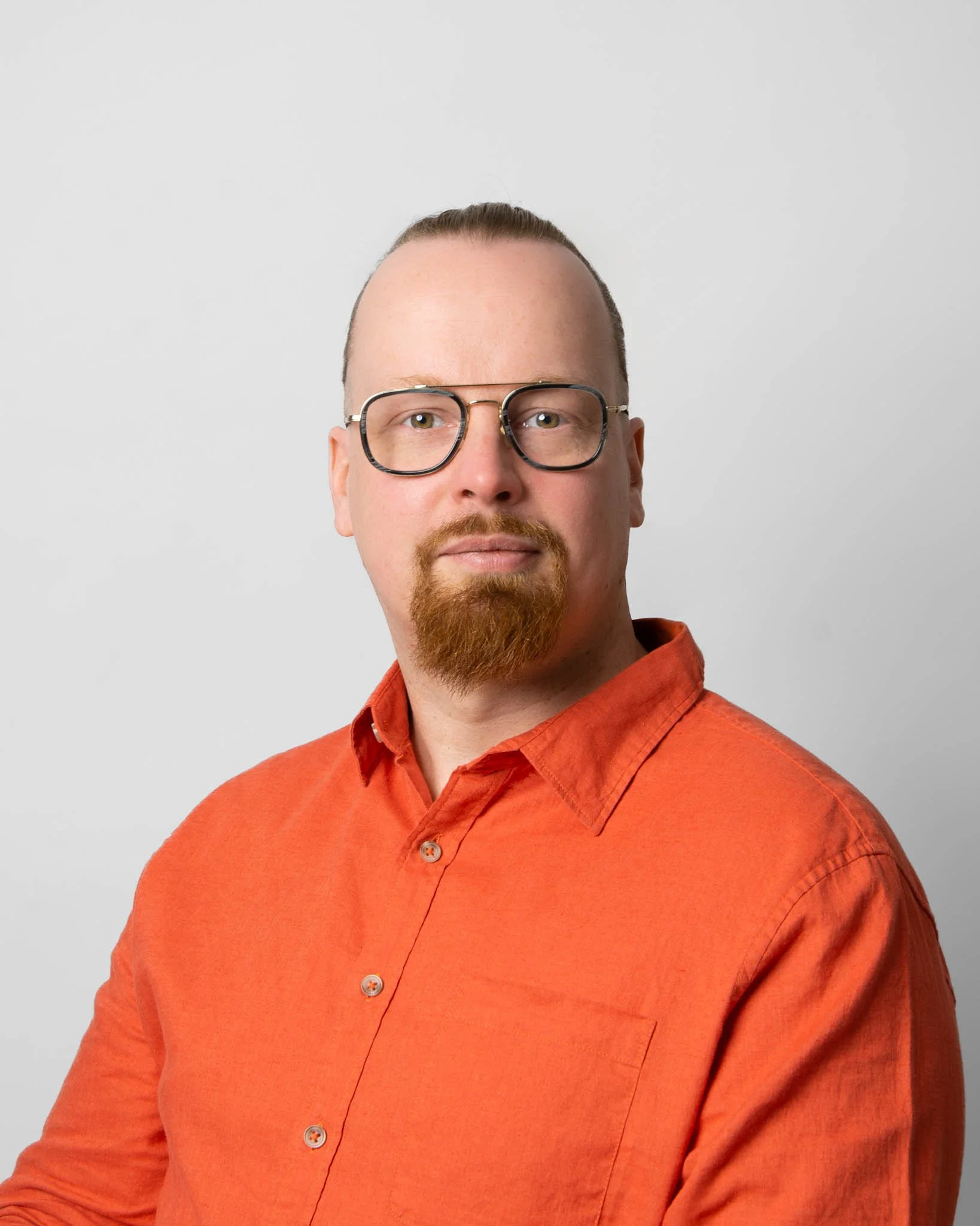 Yrityksen perustaja henkilökuvassa oranssi paita päällä