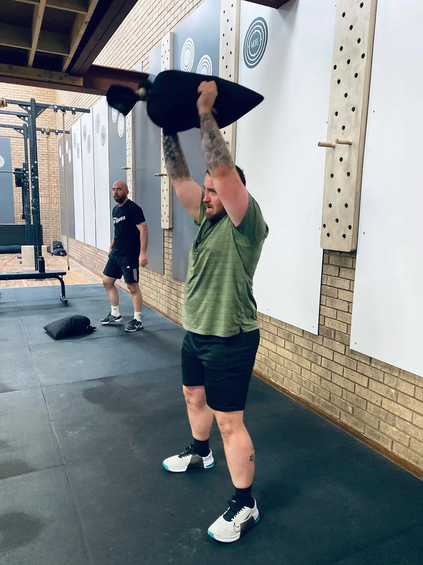 Kris &amp; Dan are ripping through today&rsquo;s WOD.

Sandbag Grinder &ndash; 3 Rounds for Time:
4 Width Sandbag Carry
5 Bear Hug Sandbag Squats
4 Width Sandbag Carry
5 Sandbag Ground-to-Overhead

Heavy carries, big lifts, and full commitment.
Solid
