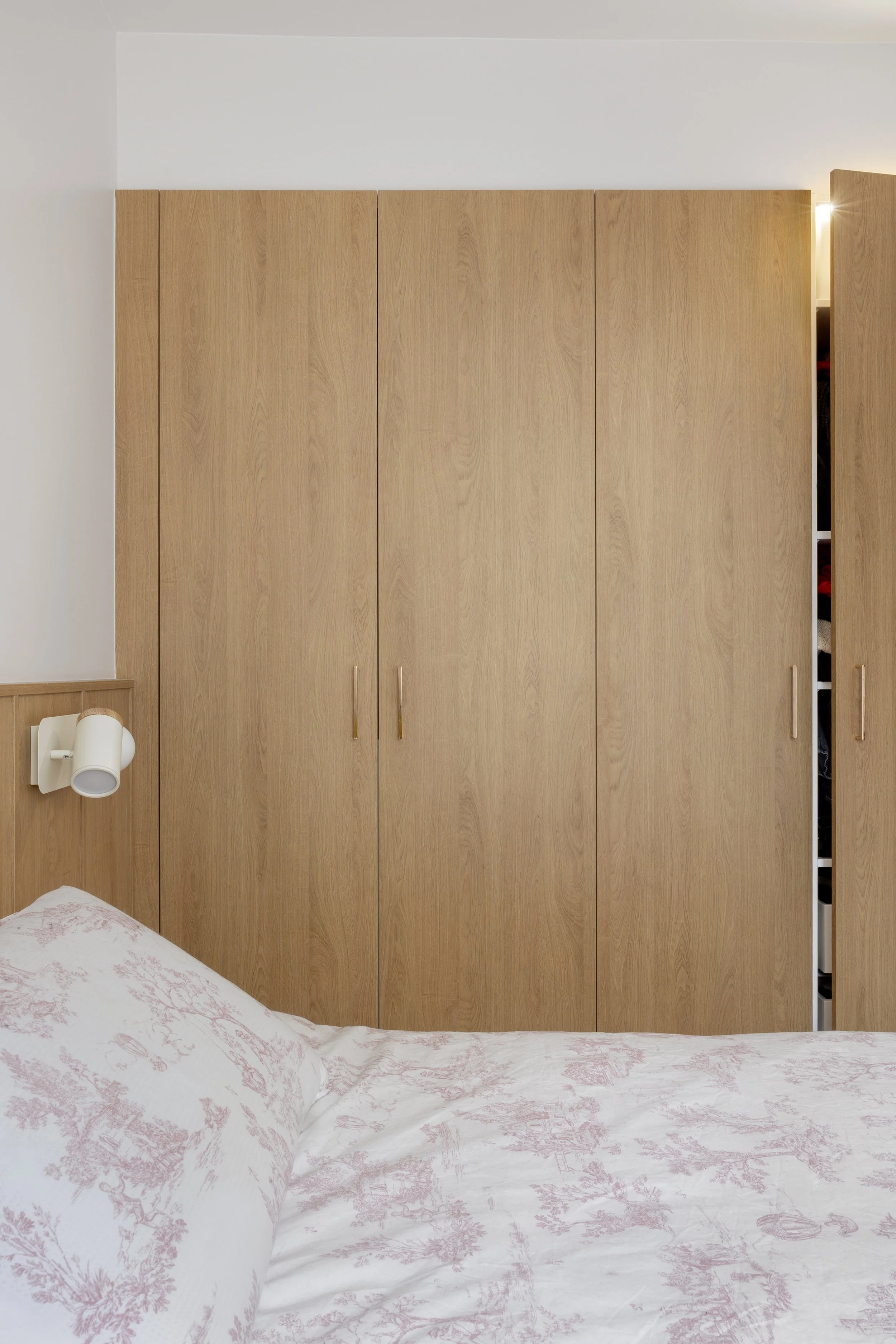 appartement sous-combles rénovation chambre parentale placard sur mesure étagères LED Tête de lit bois agggloméré mélaminé décor bois luminaire applique murale liseuse Sklum table de chevet tiroir Chatou Yvelines 