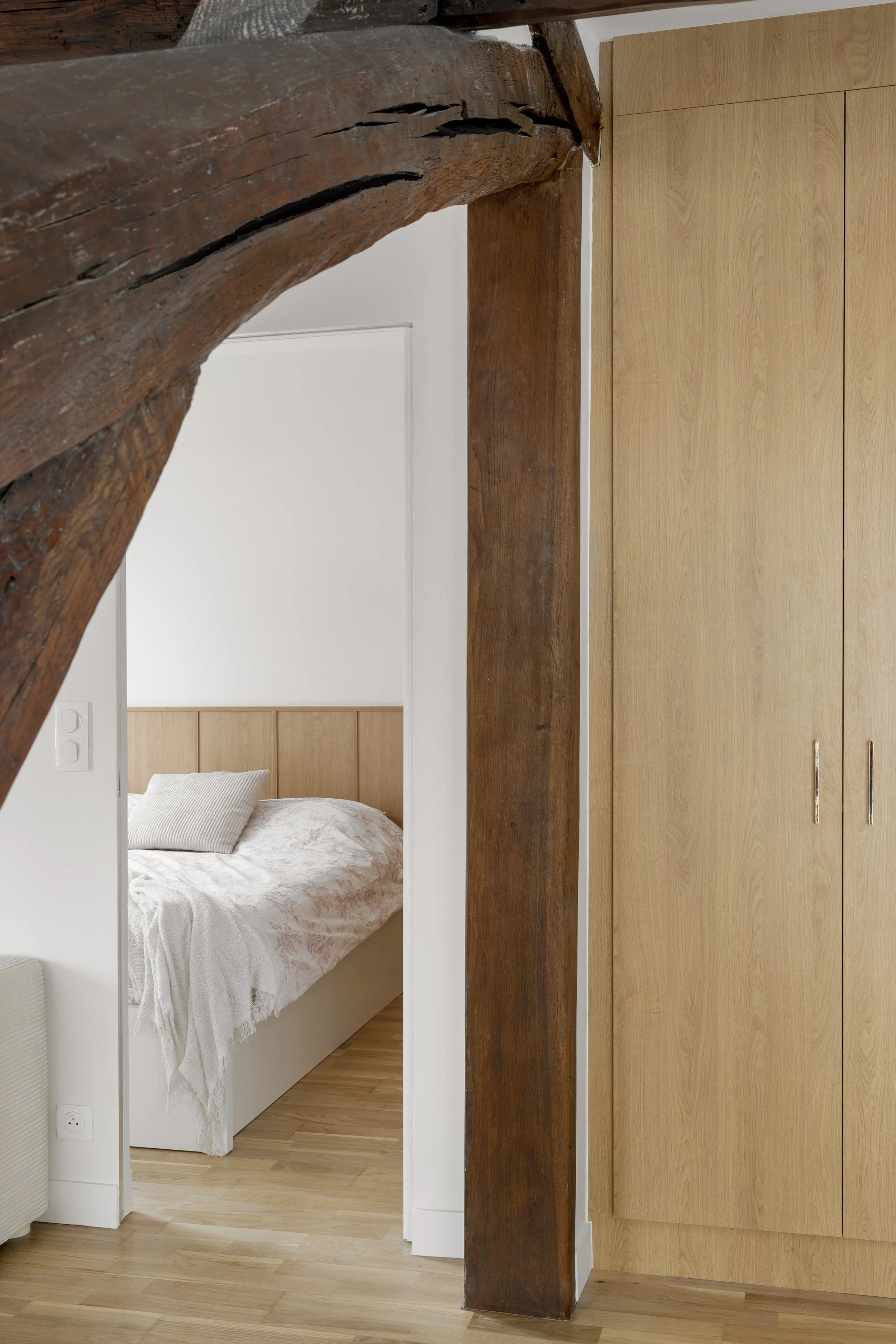 appartement sous-combles rénovation chambre parentale poutre apparente placardsur mesure parquet poncé et vernis interrupteur Legrand Tête de lit bois agggloméré mélaminé décor bois porte cadre invisble Chatou Yvelines 