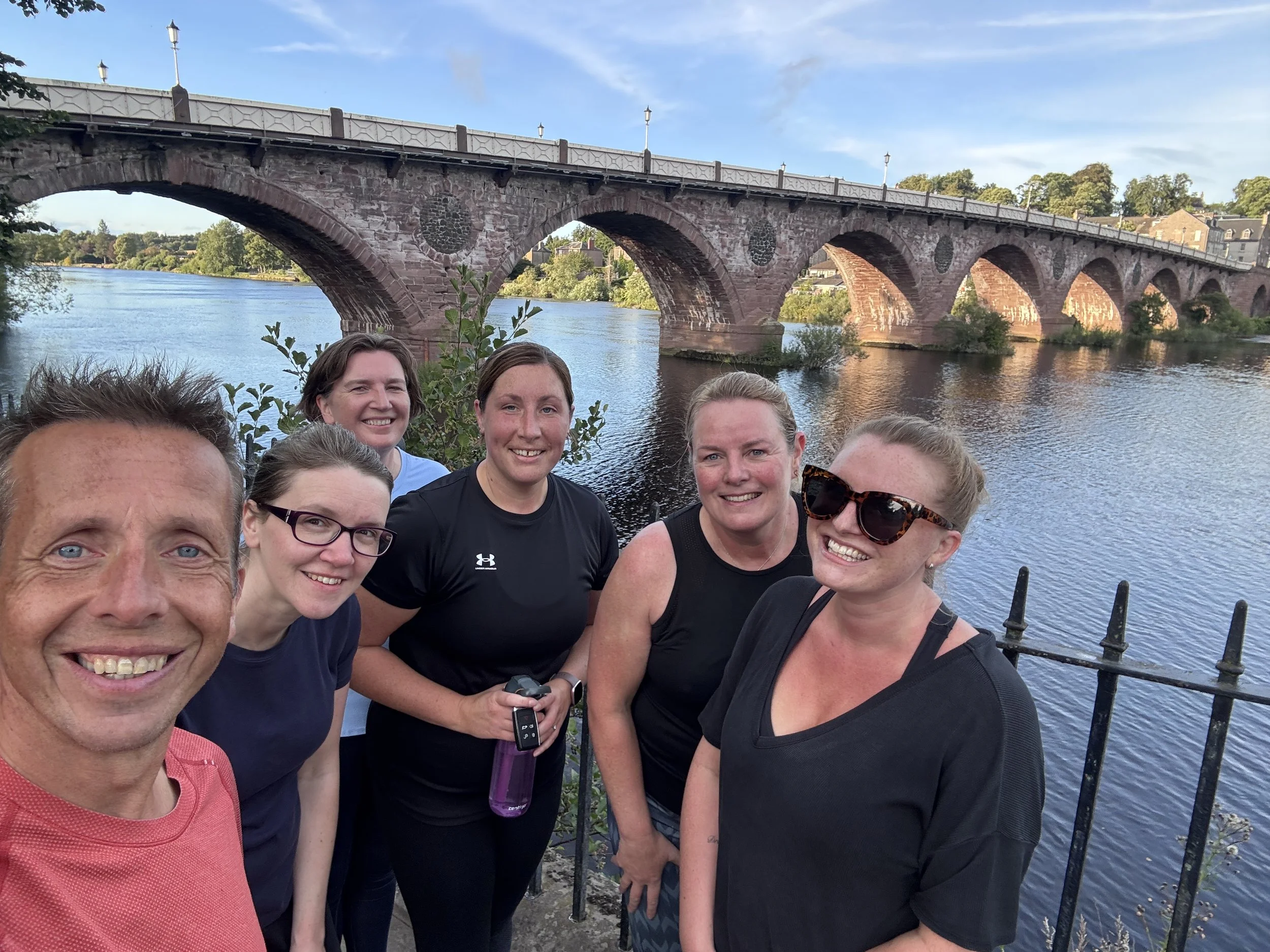 Happy runners at the end of a 0-5k in 6 weeks session with Smeatons Bridge and the River Tay in the background
