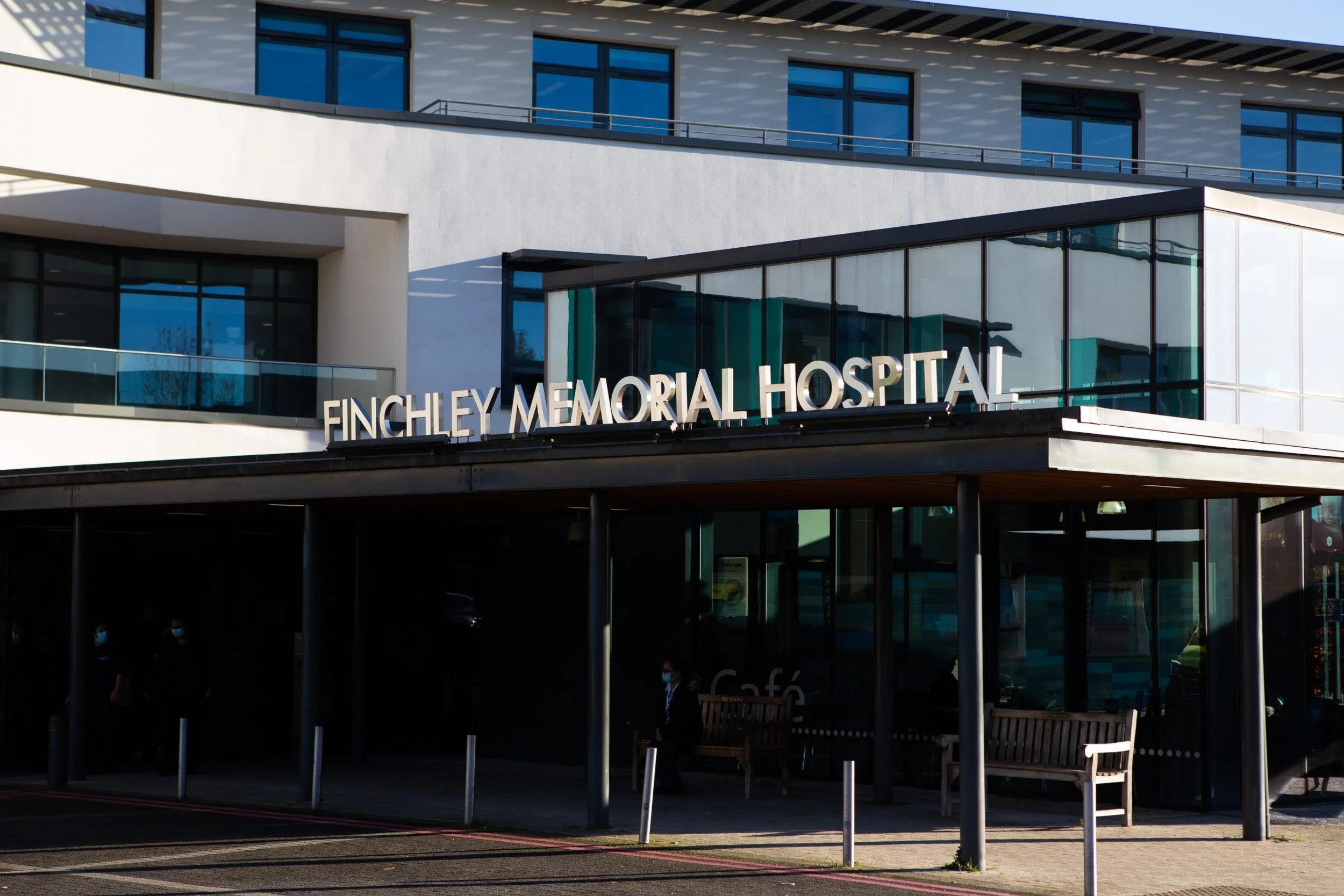 Front view of Finchley Memorial Hospital building with glass facade and entrance, with the hospital's name visible on the sign.