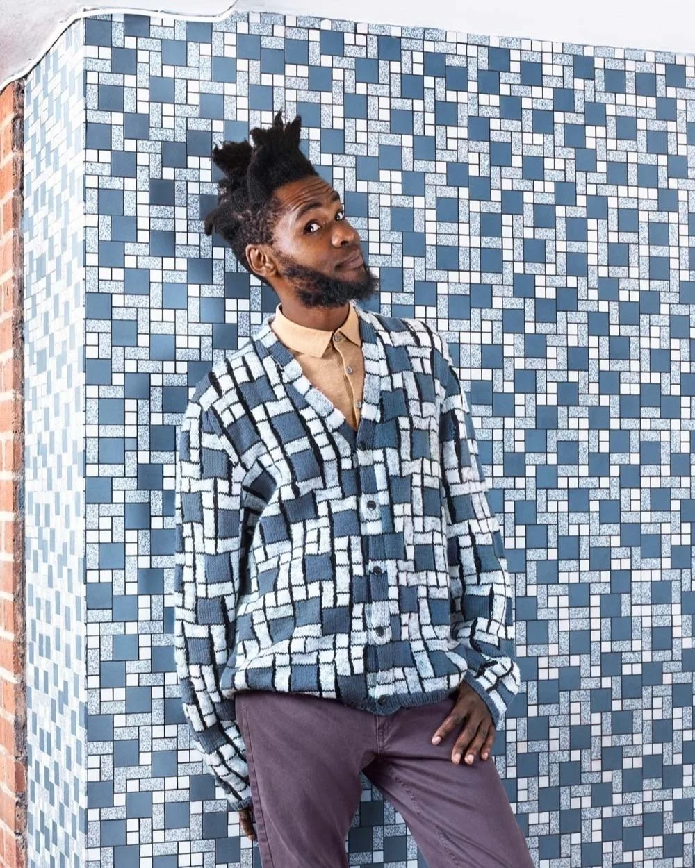 Animated GIF of a man blending into a tiled wall wearing a matching hand-knitted jumper, created by Joseph Ford for a camouflage fashion and visual illusion photography series