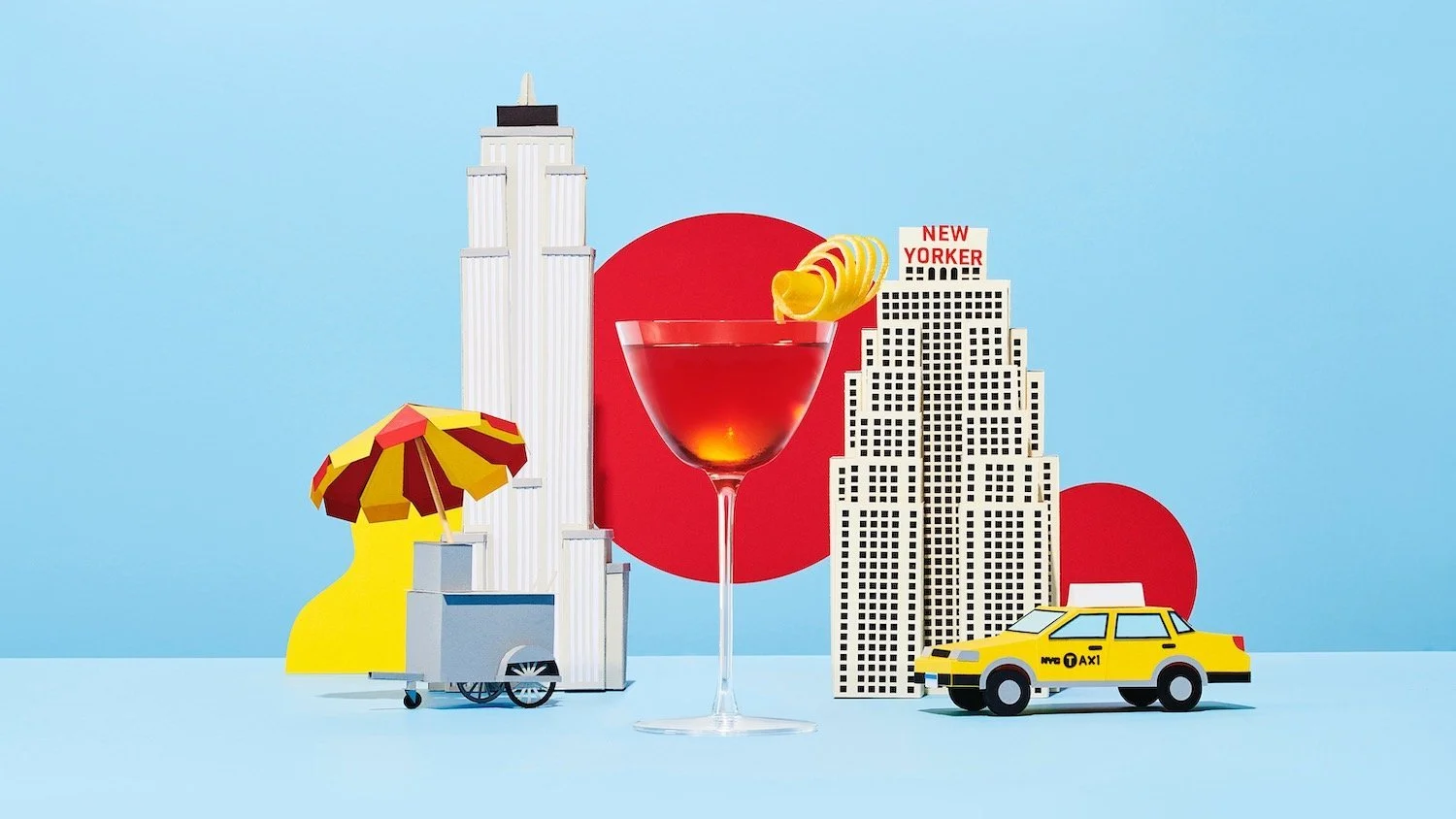 A cocktail in front of a miniature New York landscape, creative drinks photography by Frankie Turner