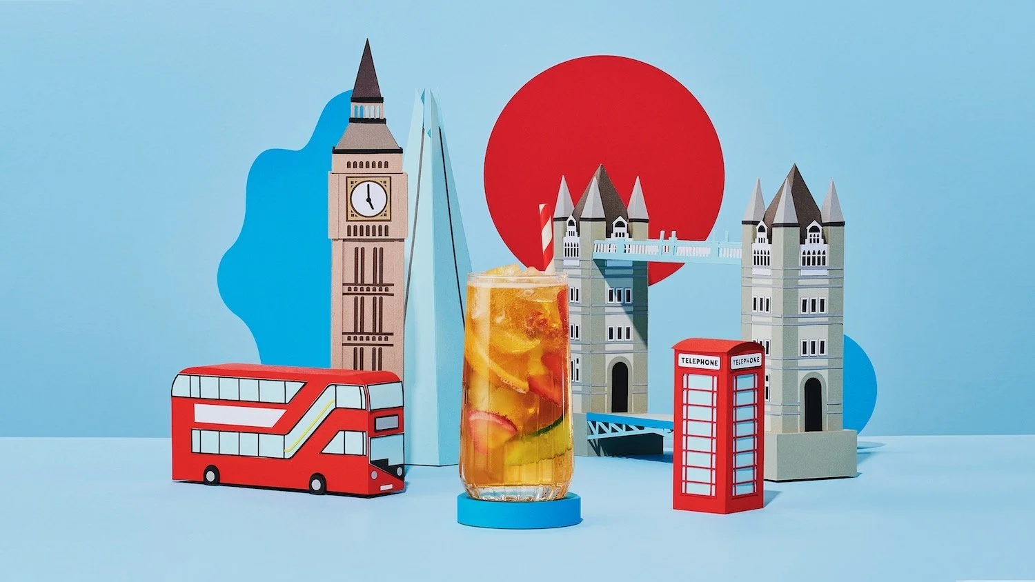 A cocktail in front of a miniature London landscape, creative drinks photography by Frankie Turner