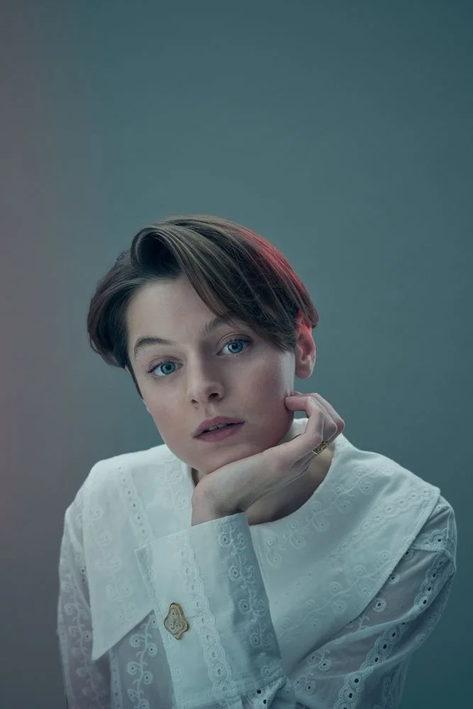 Thoughtful studio portrait of actor Emma Corrin, photographed by Phil Fisk in London. Editorial style with muted tones and cinematic lighting, capturing vulnerability and quiet intensity.